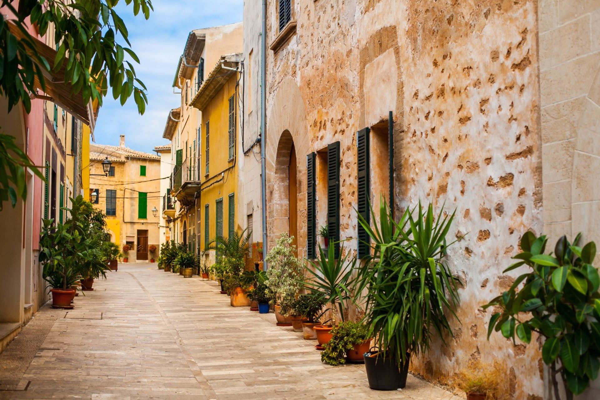 The narrow paved streets of the old town Alcudia, decorated with flower pots.