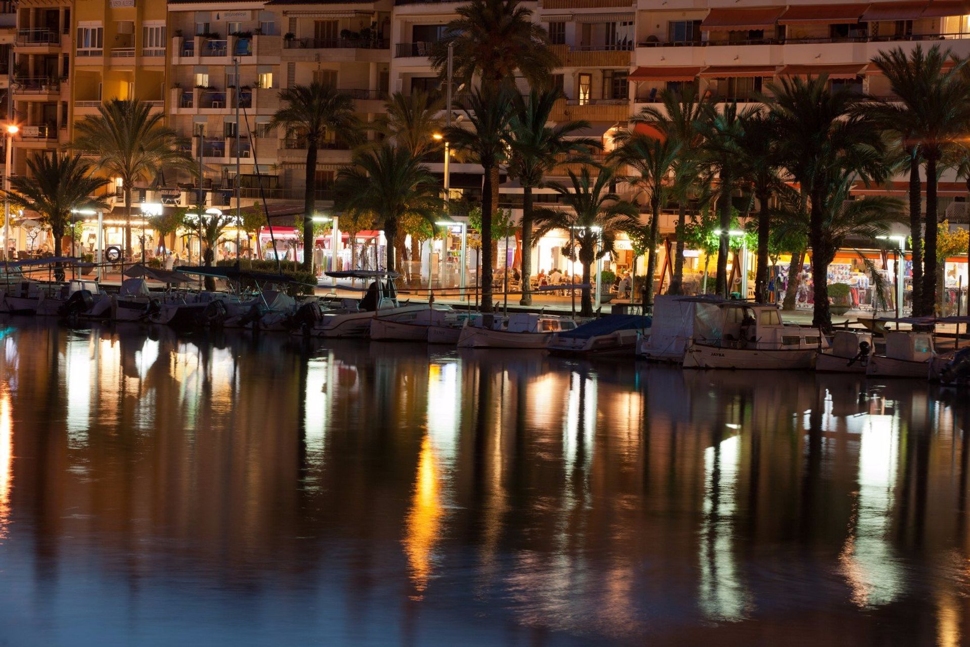 Alcudia's lights at night reflecting on the water