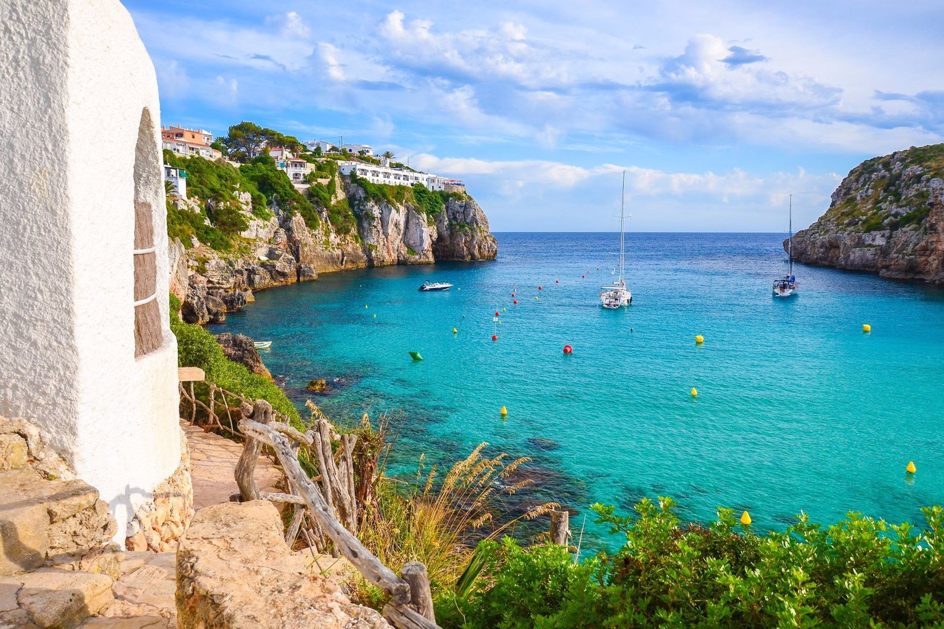 Yachts moored on the turquoise waters of Cala en Porter bay, south eastern Menorca