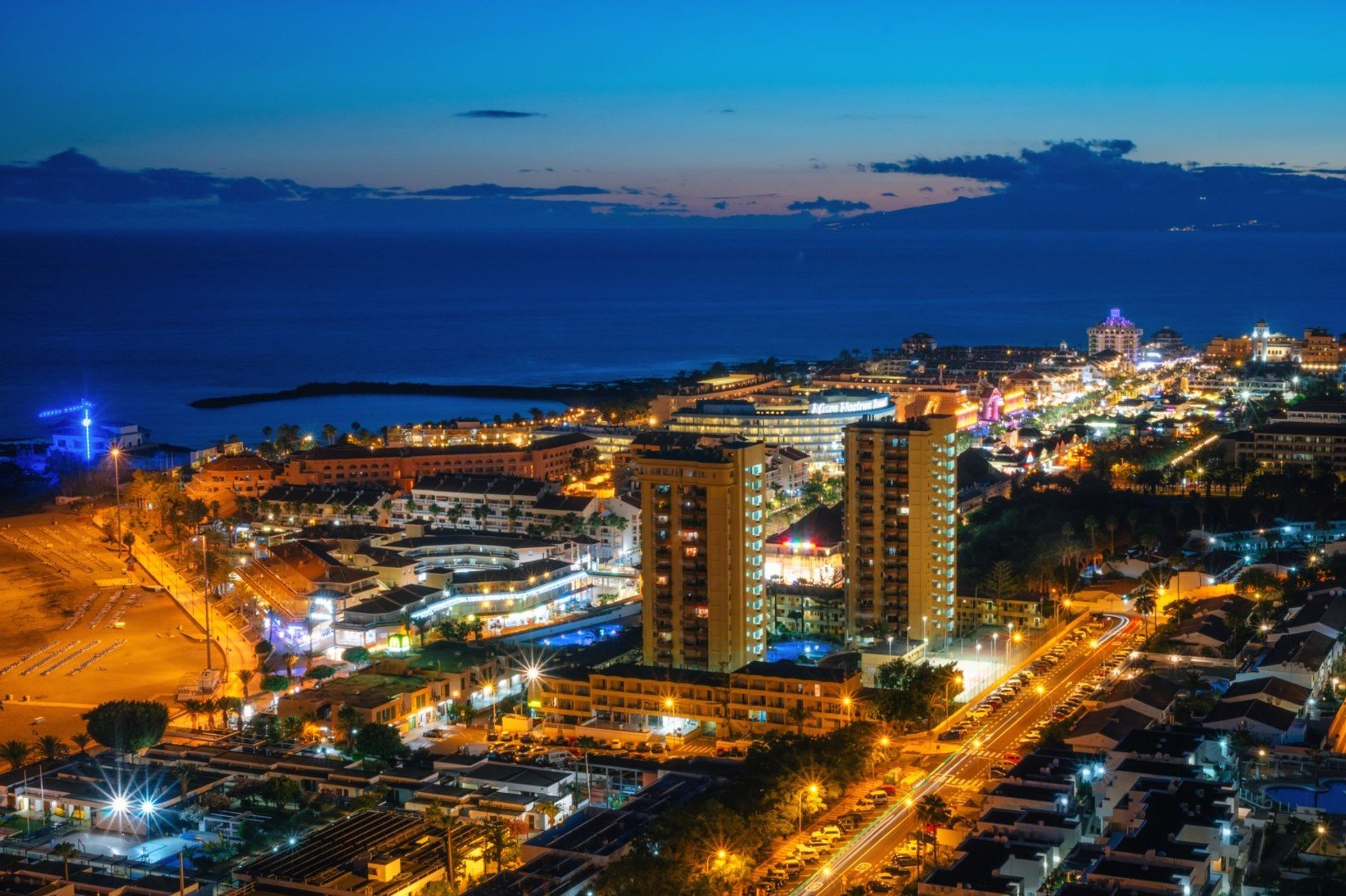 Playa de Las Americas lit up against the night sky