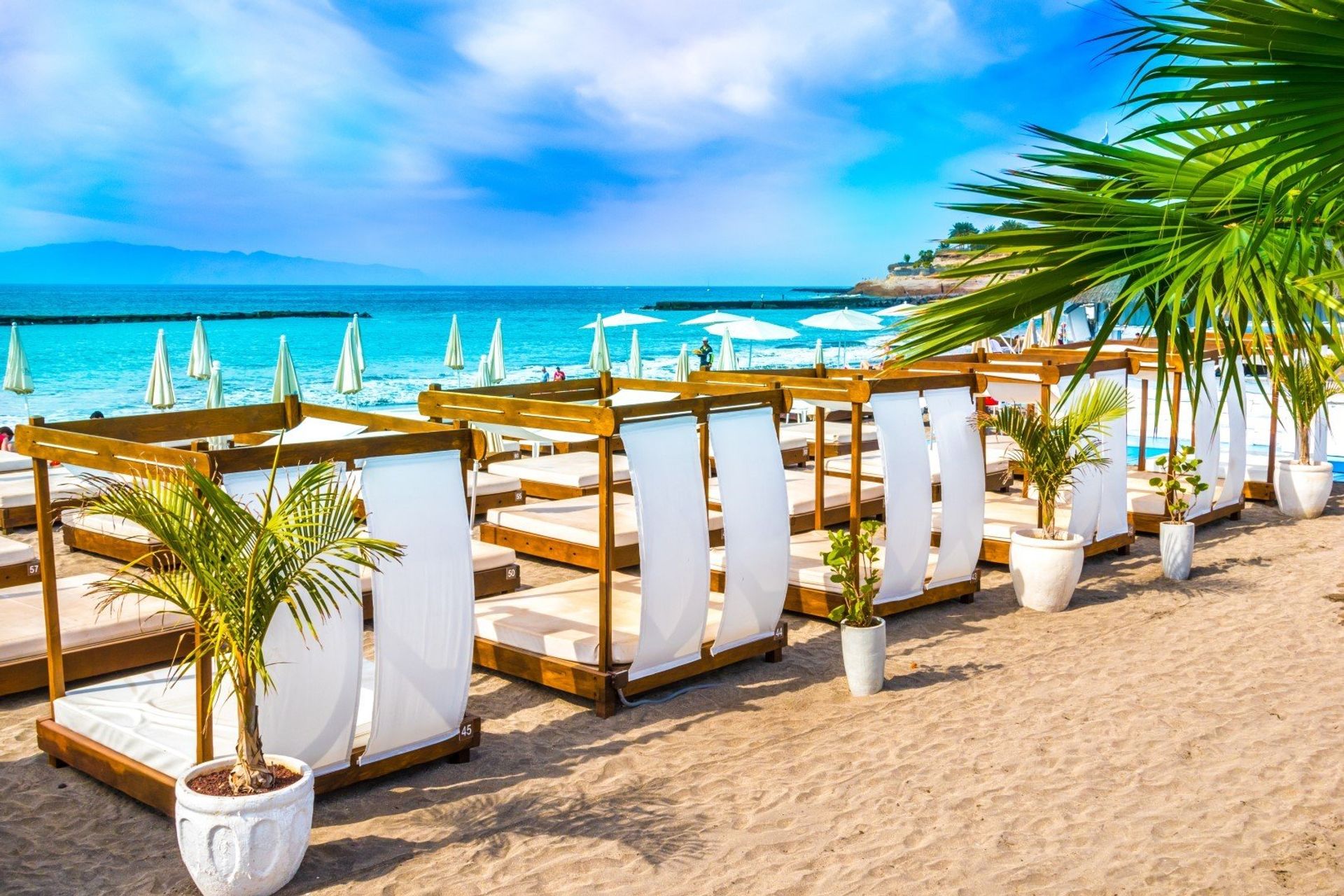 White cabanas on Costa Adeje beach with its turquoise waters and golden sand on the south coast of Tenerife