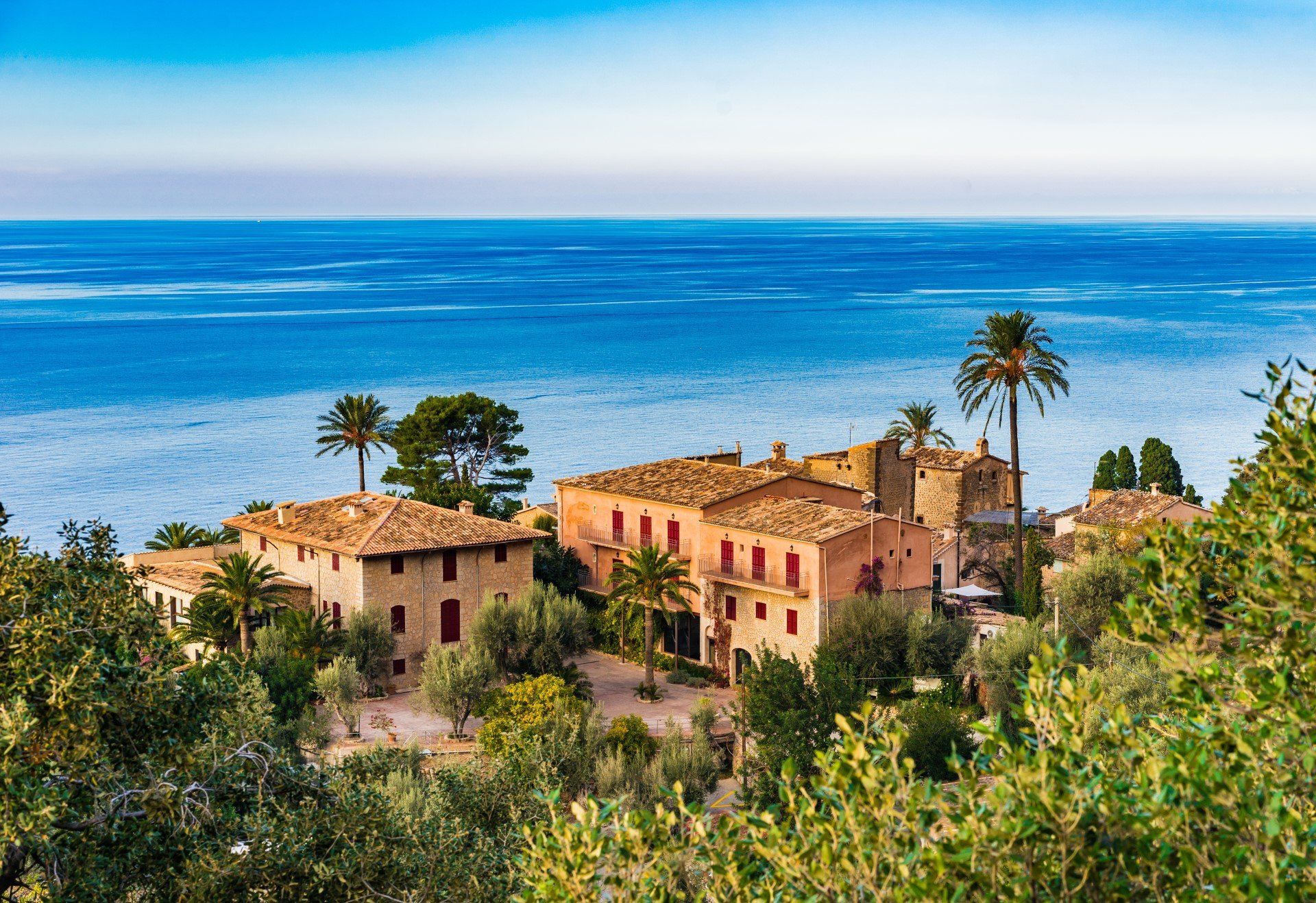 Rustic Majorcan houses with the azure Balearic sea in the background