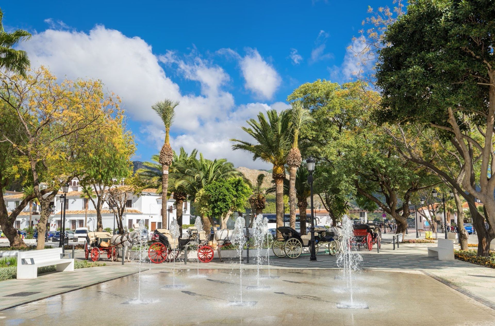Fountain and horse carriages in the town centre of Mijas