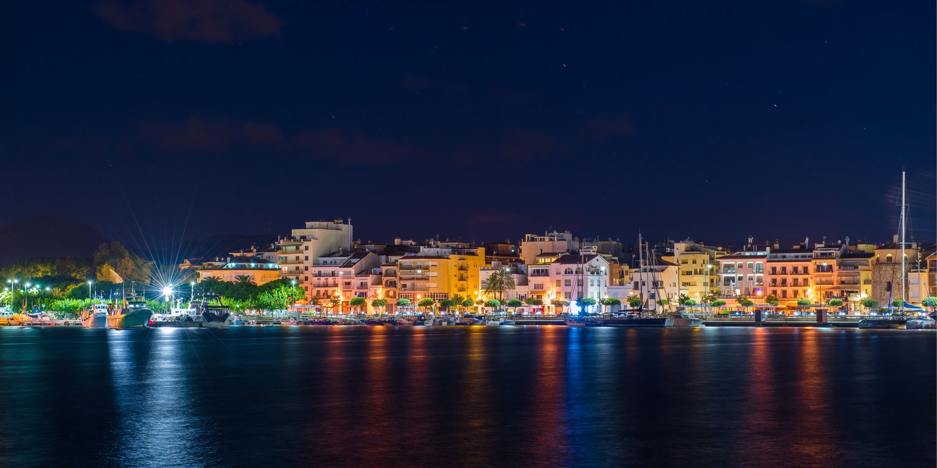 Cambrils and its harbour lit up against the night's sky