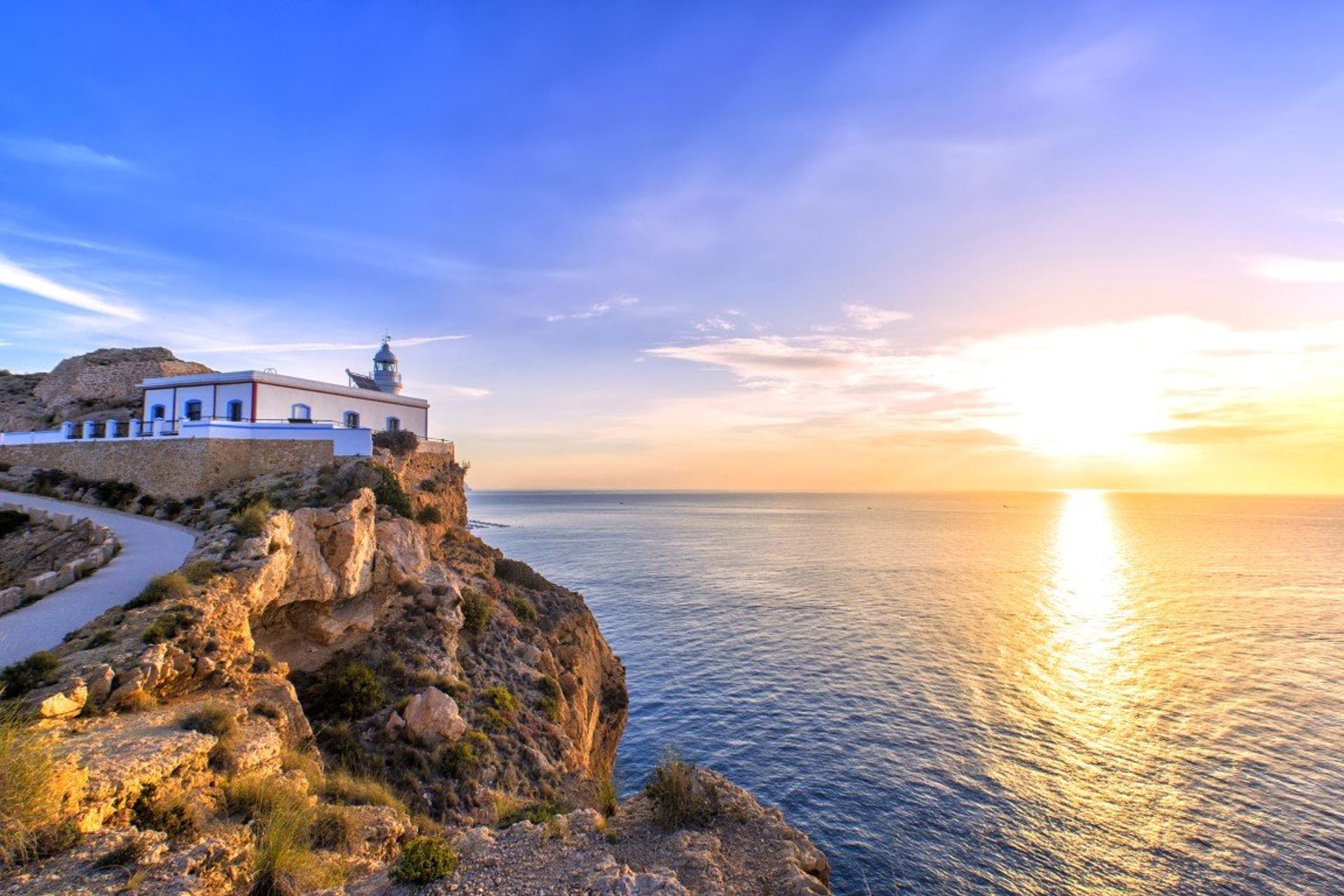 Watch the sun set from Albir beach lighthouse overlooking the Mediterranean