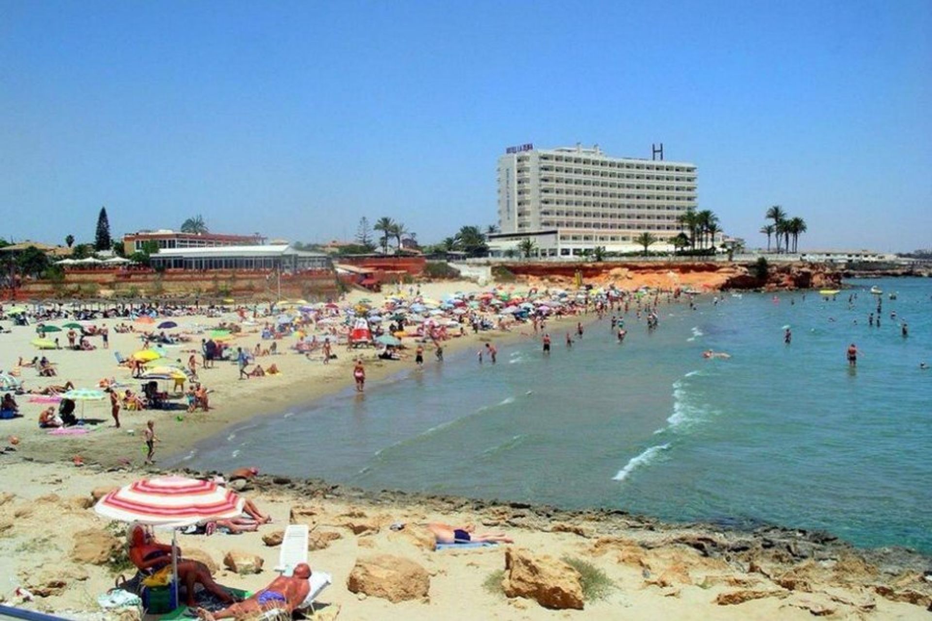 People watch on La Zenia beach, just a stone's throw away from the main shopping centre