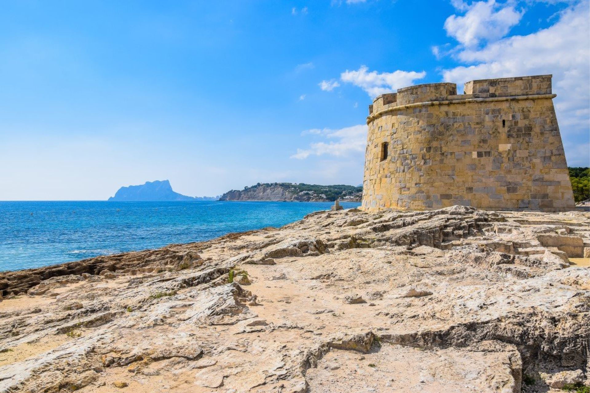 18th century Moraira Castle with Calpe's natural park Penon de Ifach in the distance