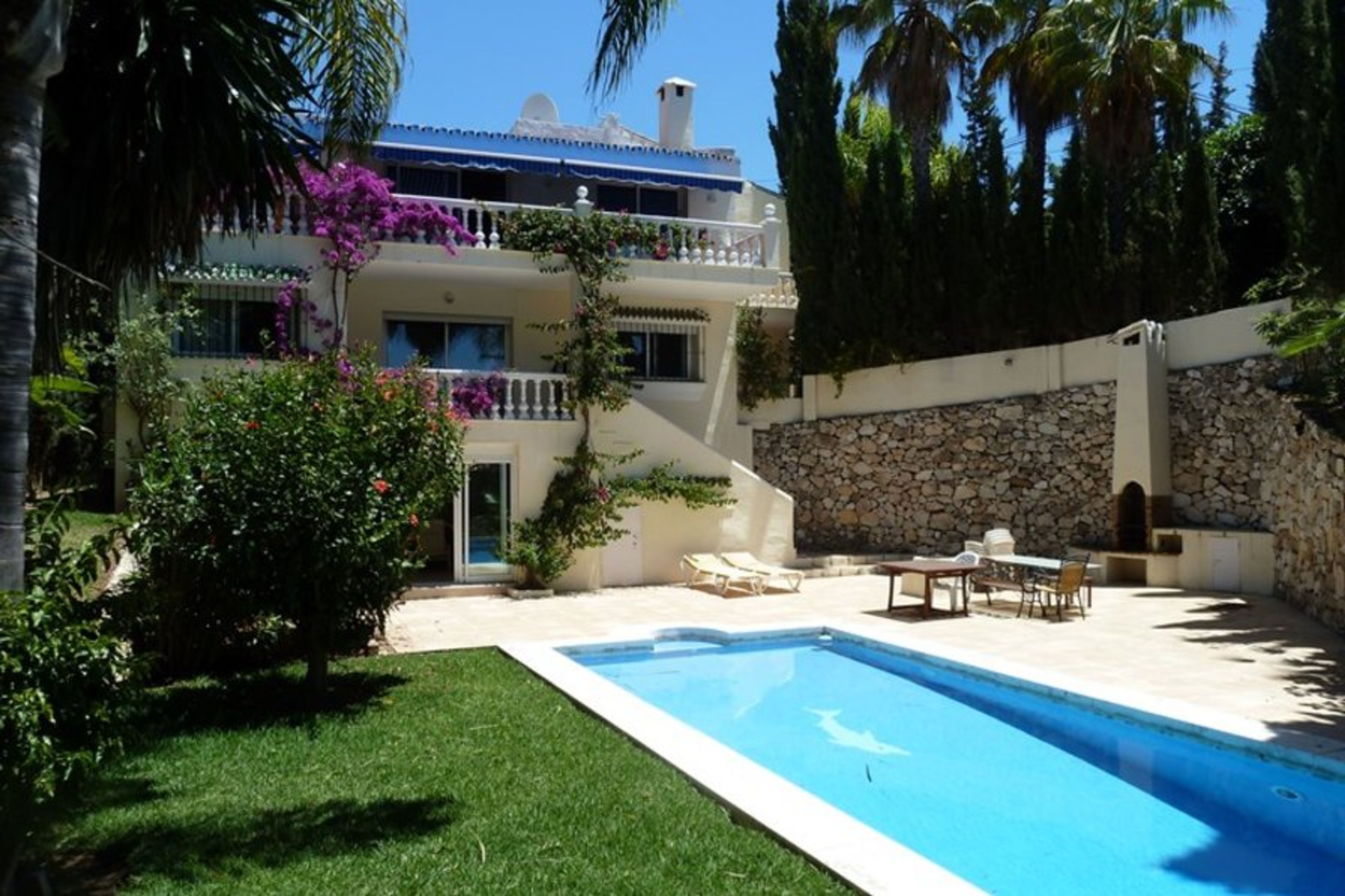 Rear garden and swimming pool with patio area and out door furniture