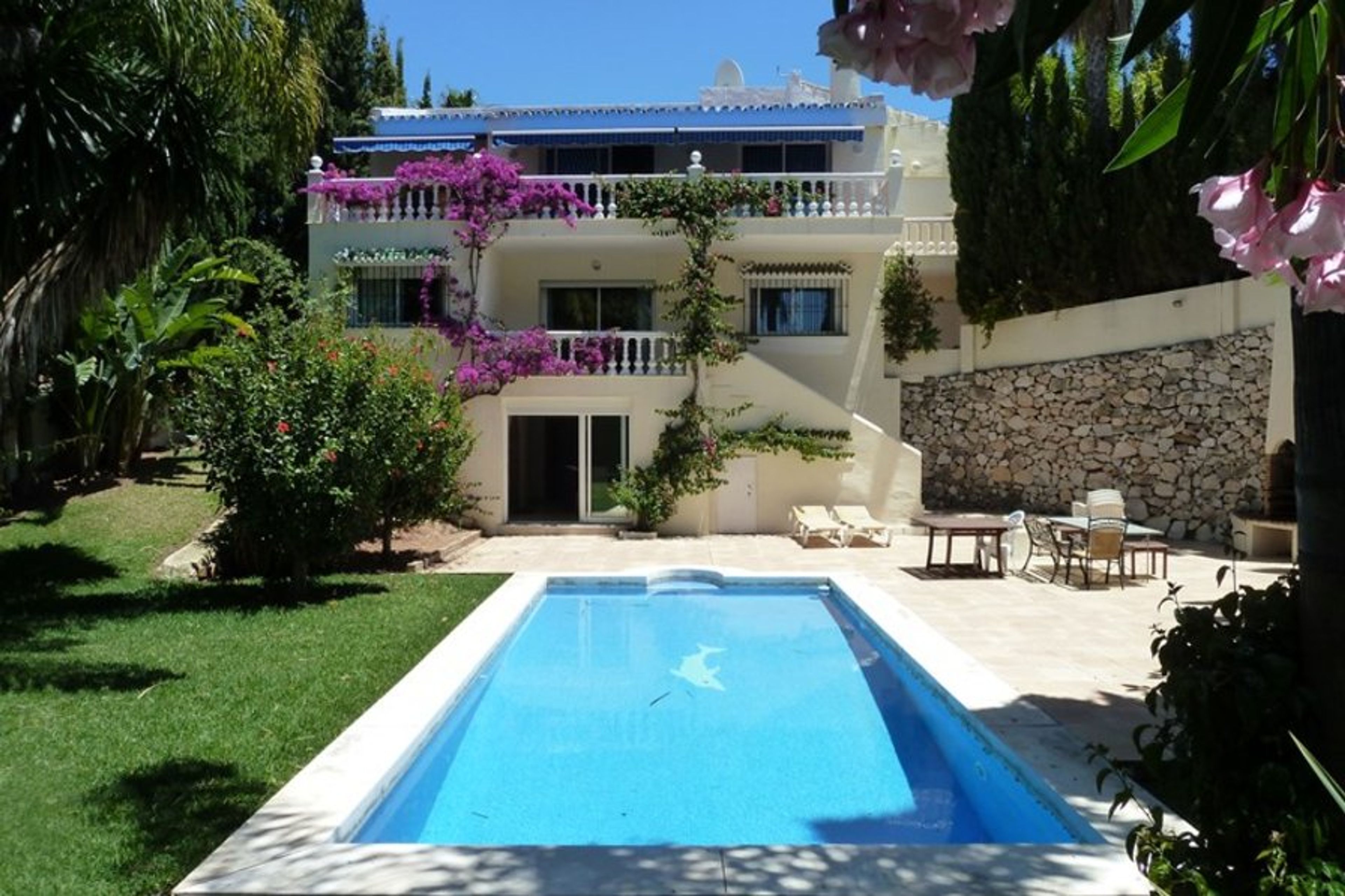 View of rear garden, swimming pool and back of villa