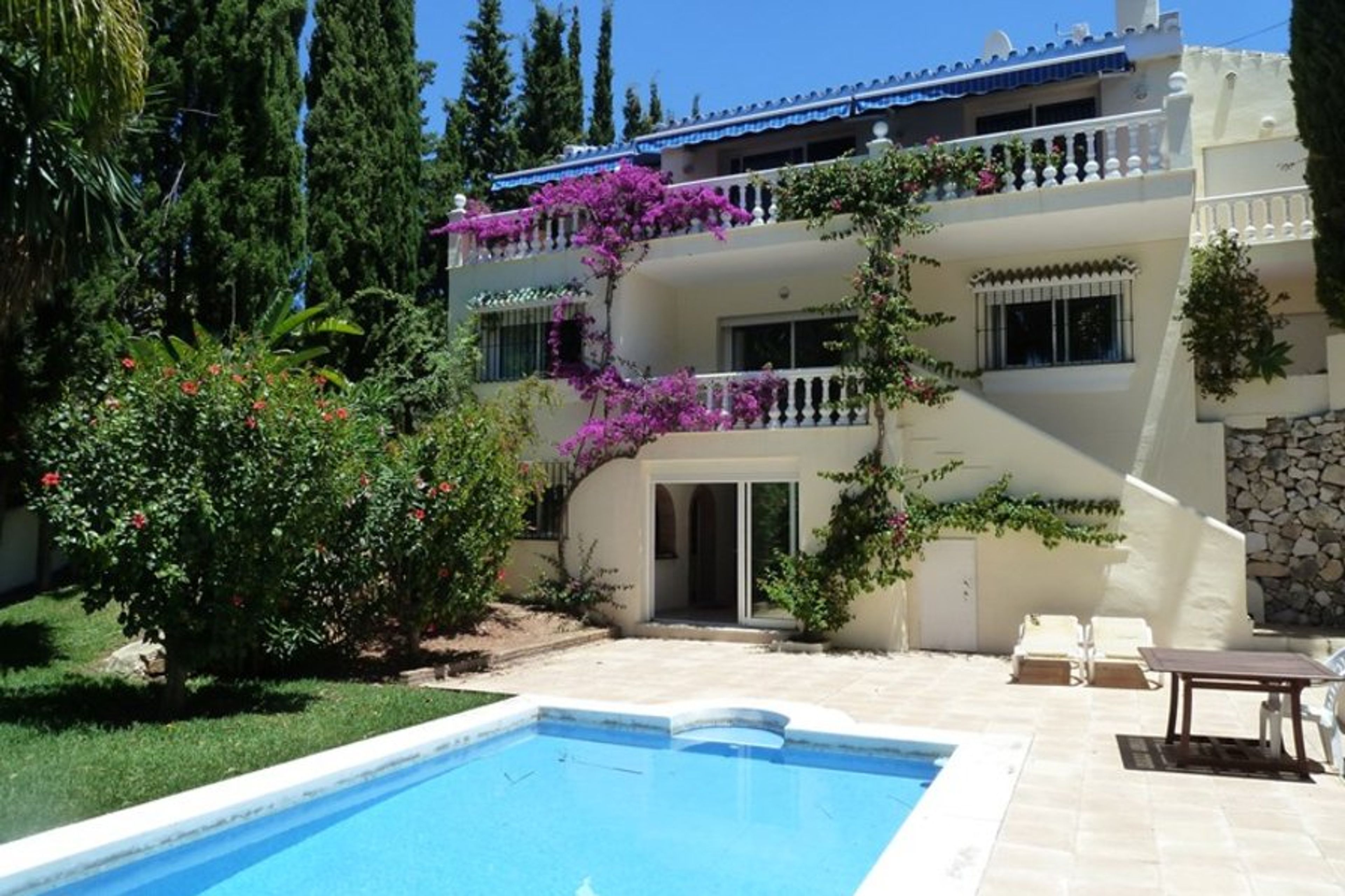view of swimming pool patio area and back of villa