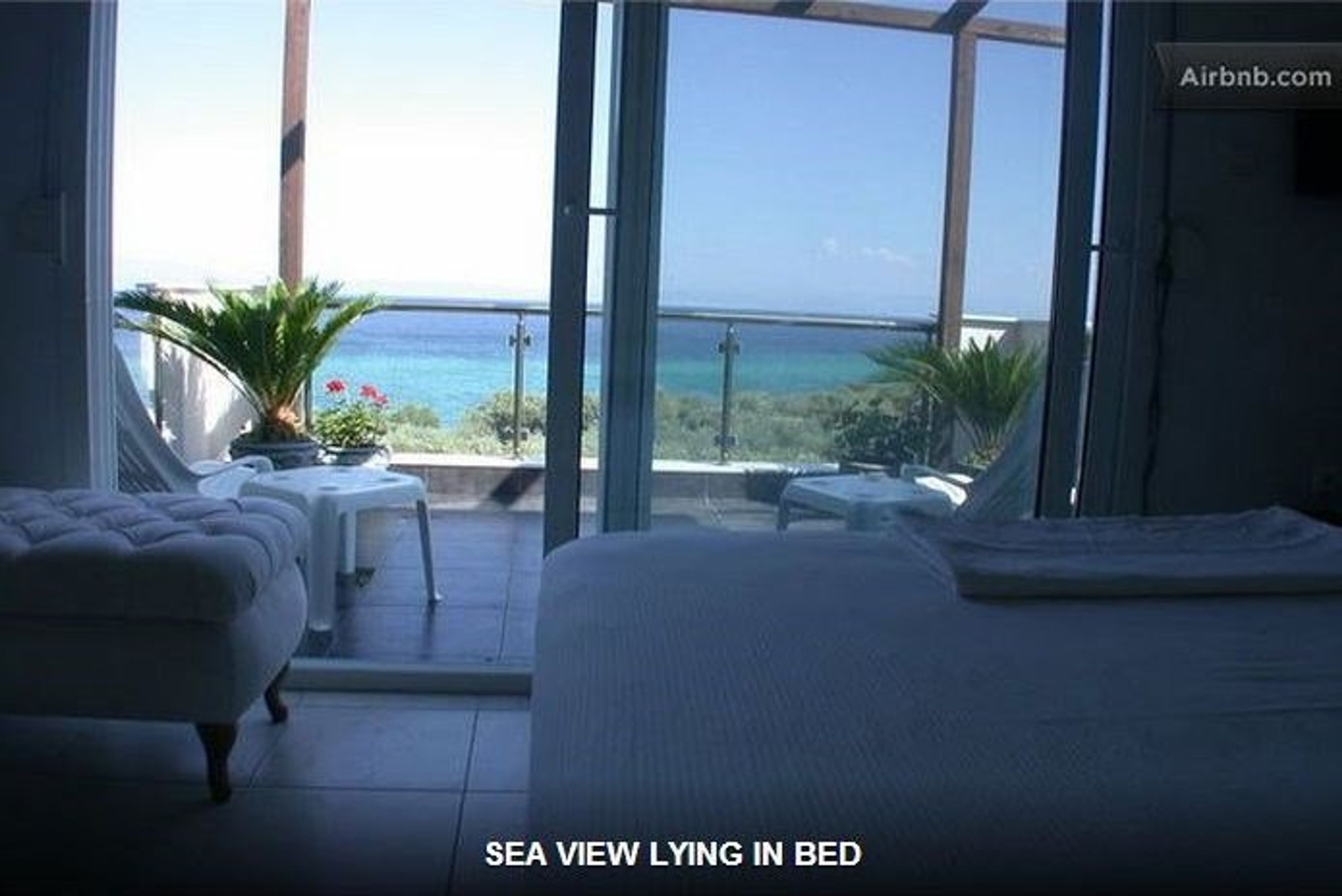 Ocean view by person lying in bed in master bedroom.