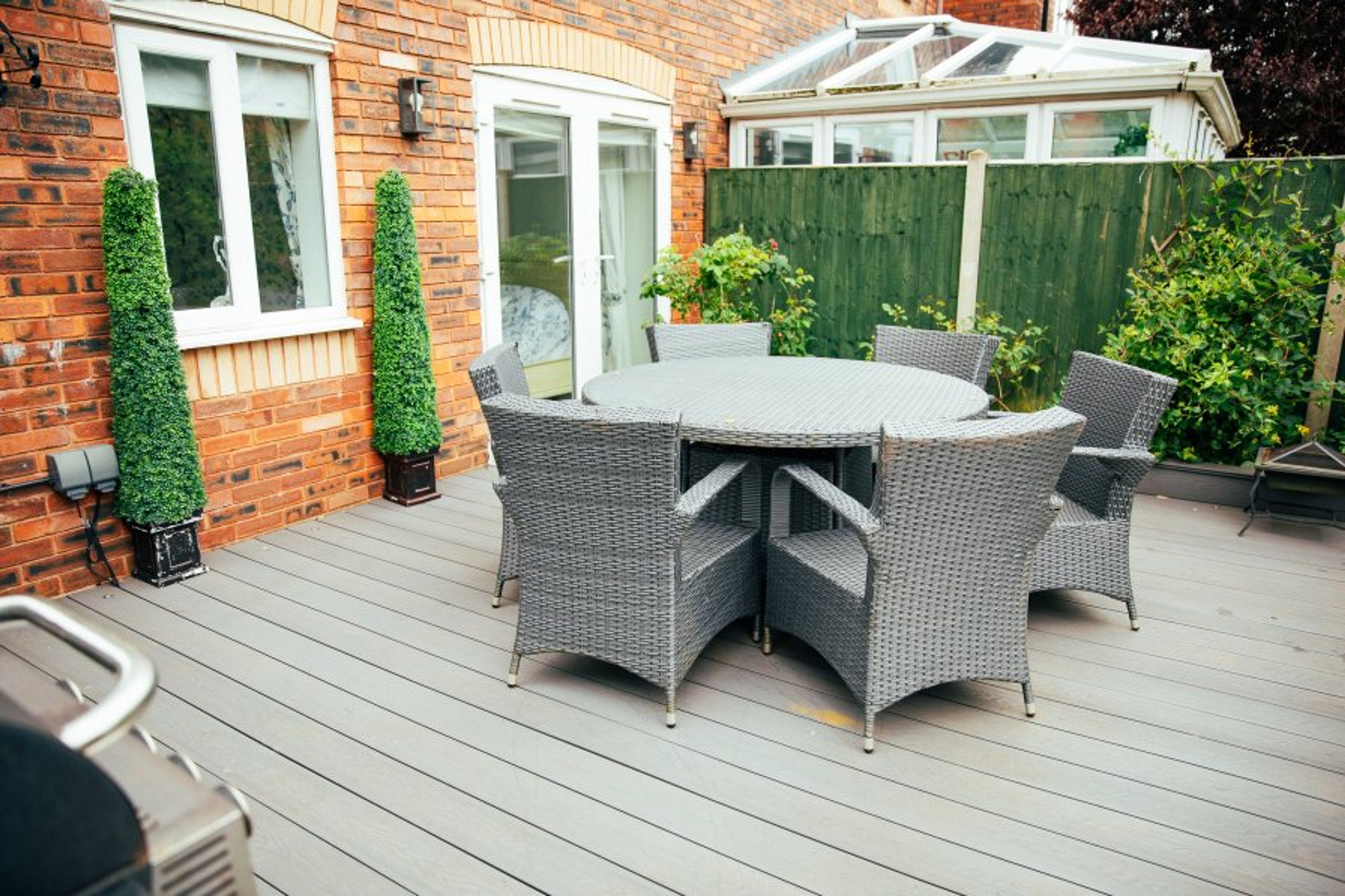Lovely patio and duel fuel bbq with lighting on the walls and decking