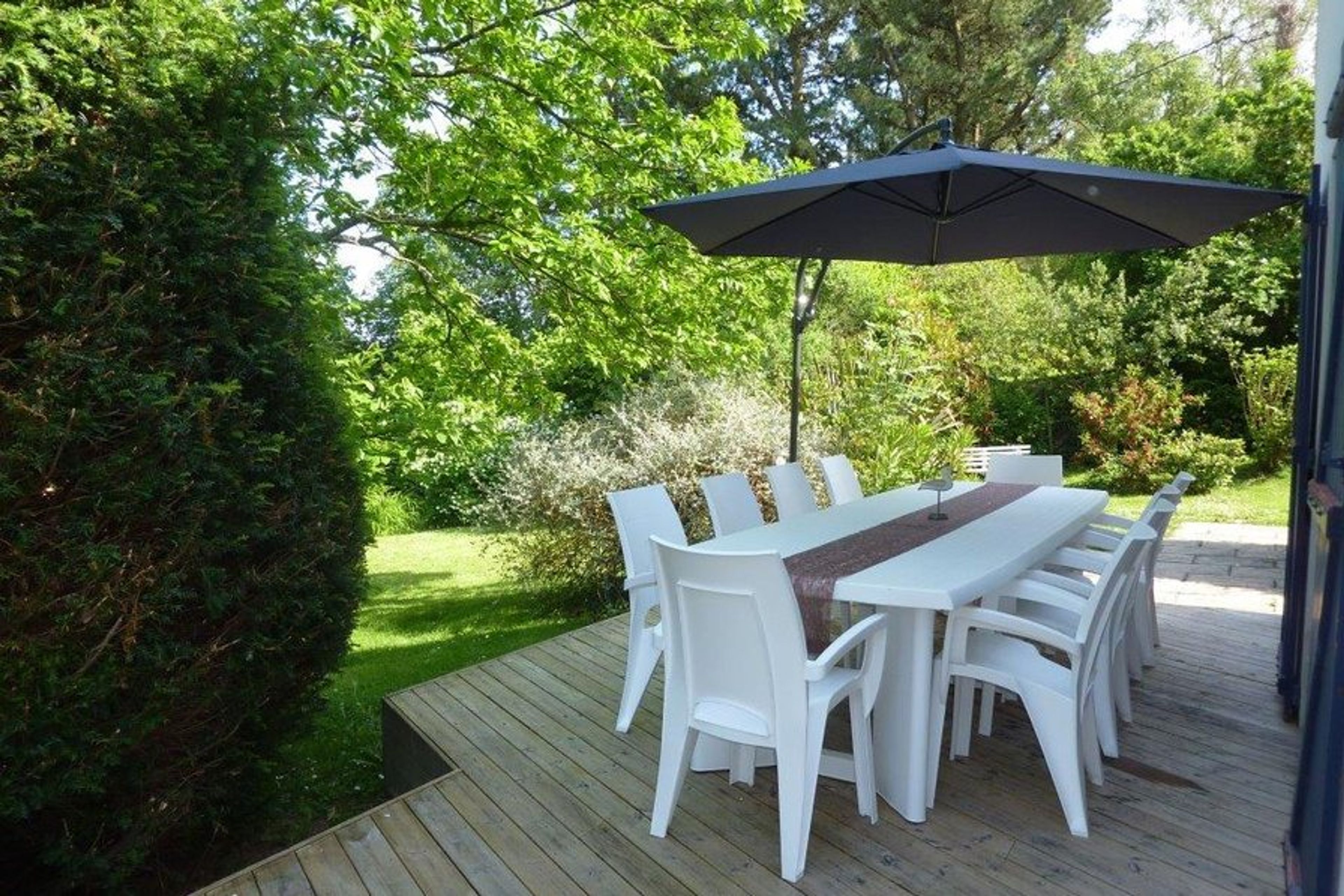 Dining furniture on the decked terrace overlooking garden.