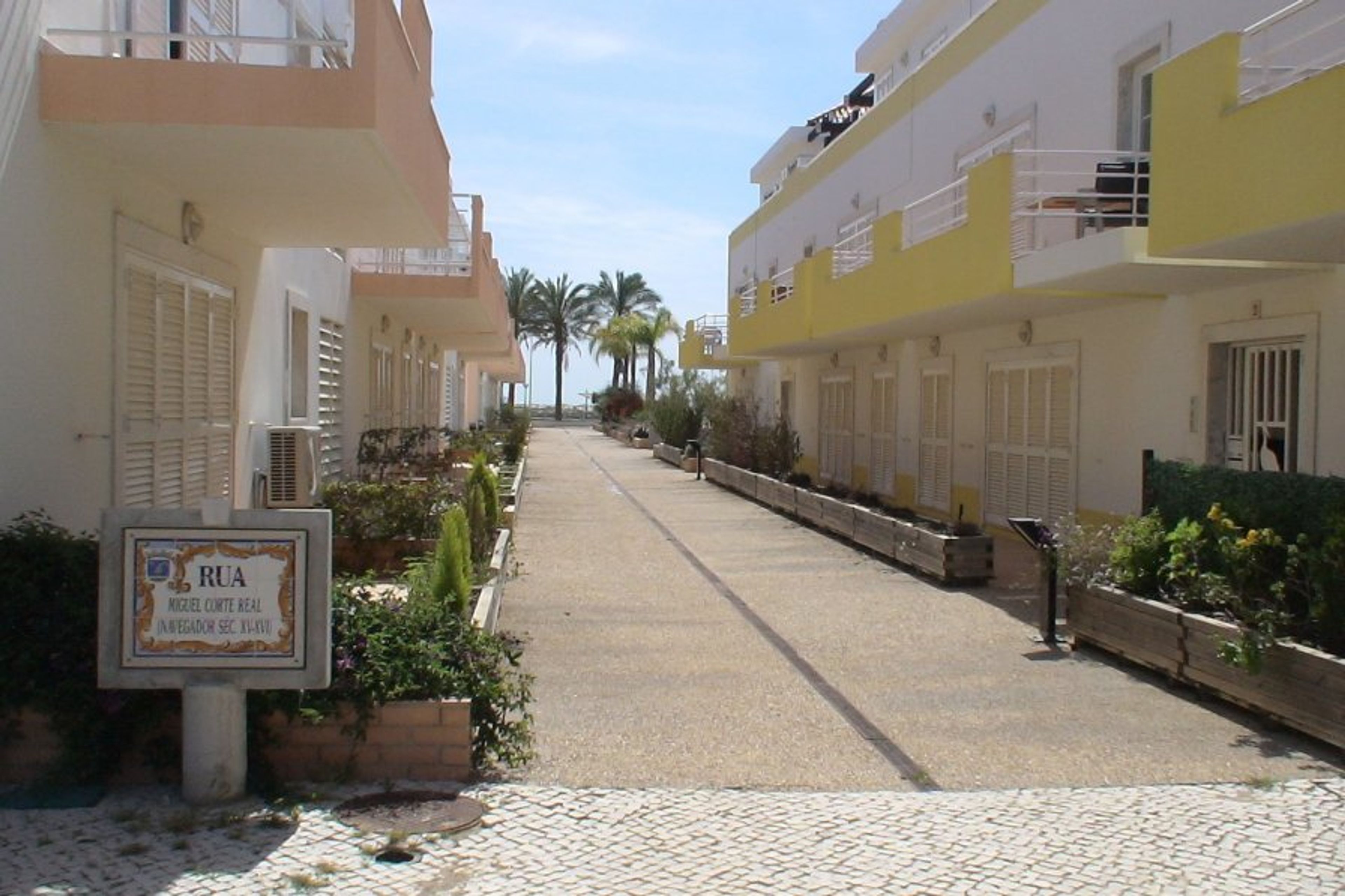 Rear of apt block down to the waterfront where the palm trees are seen