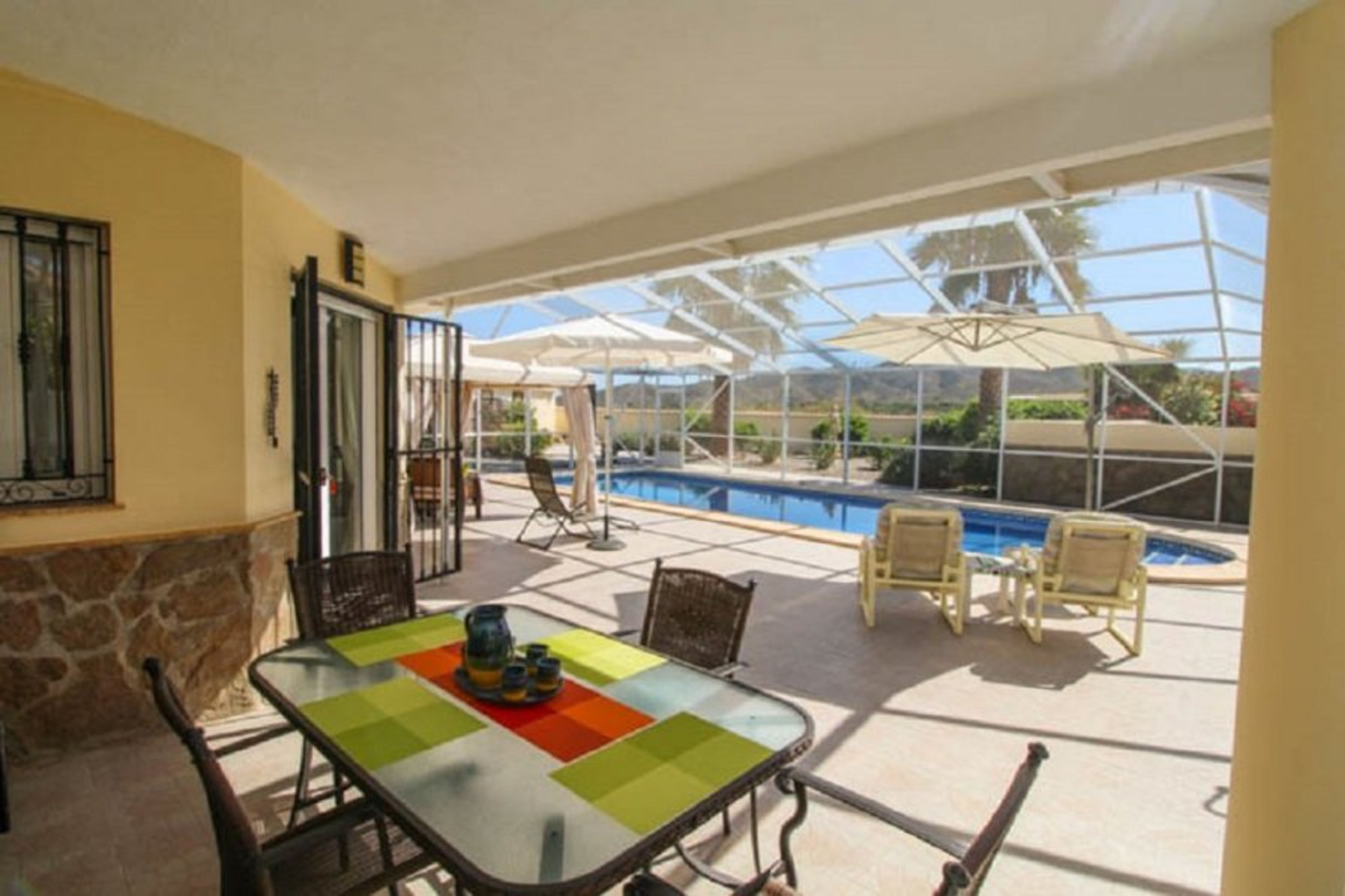 Refreshing swimming pool, table, chairs and a fly-free enclosure.  