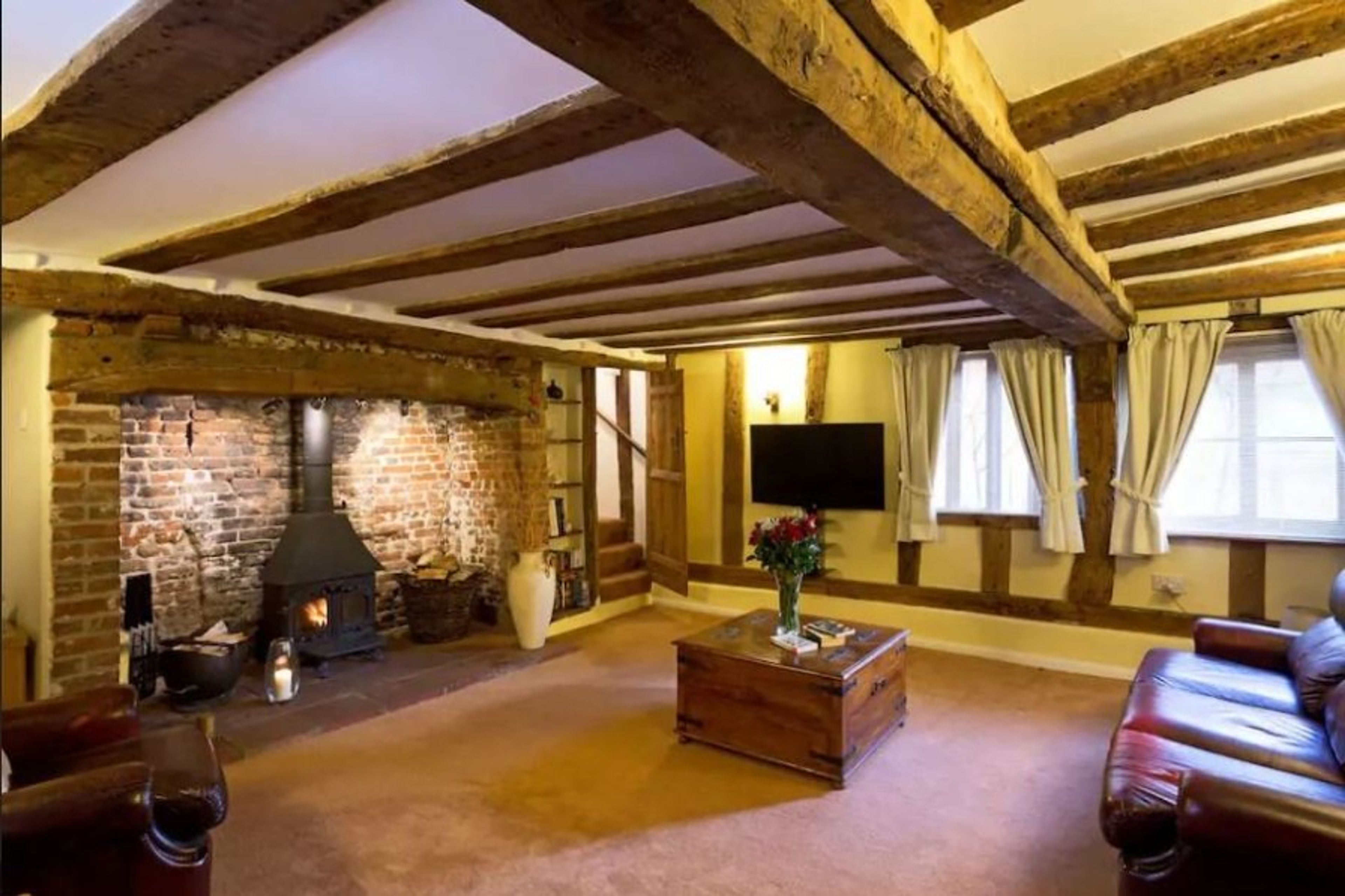 Lounge with large inglenook fireplace and exposed beams.