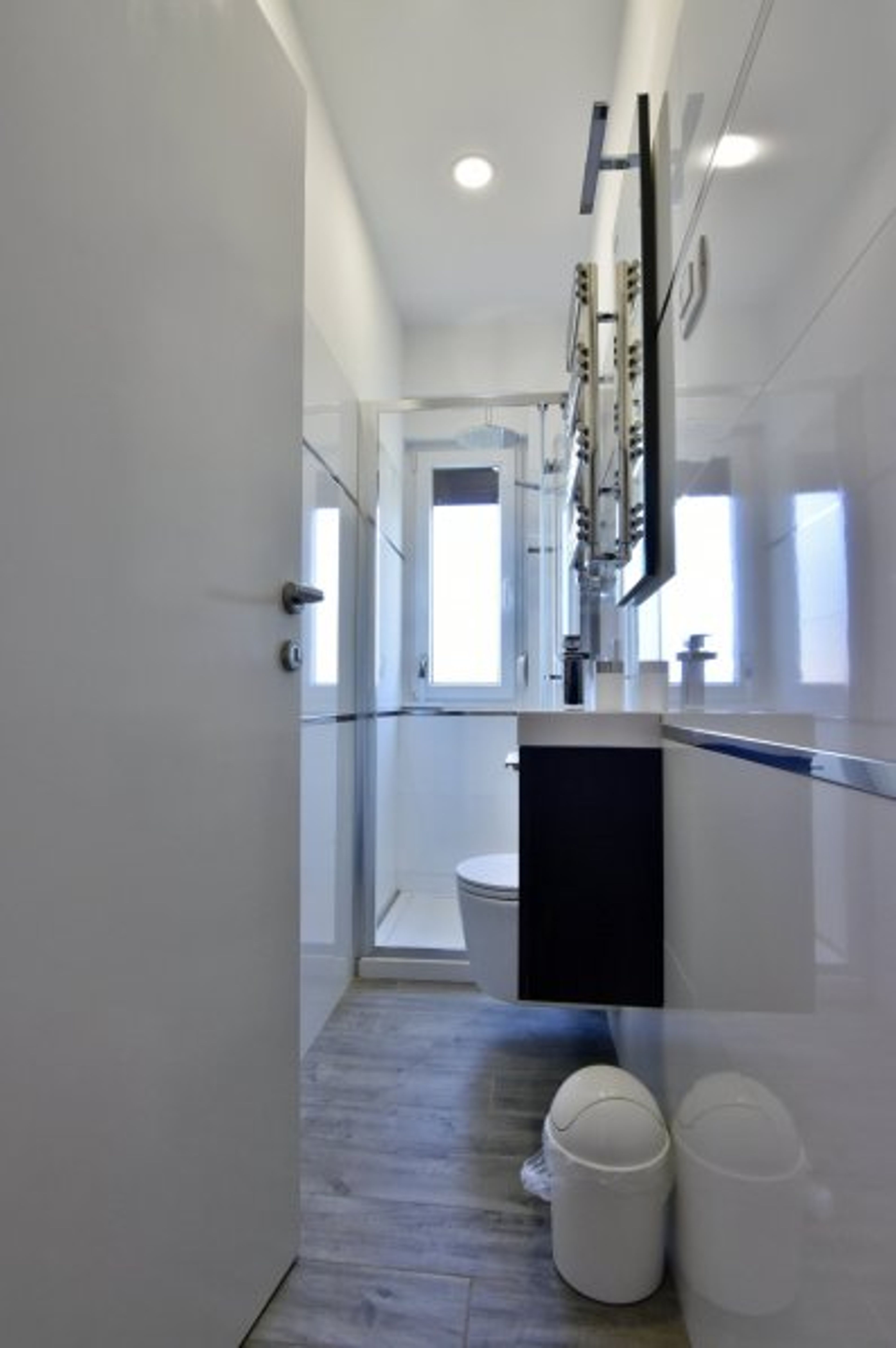 Bathroom with shower, sink with cabinet and mirror, toilet