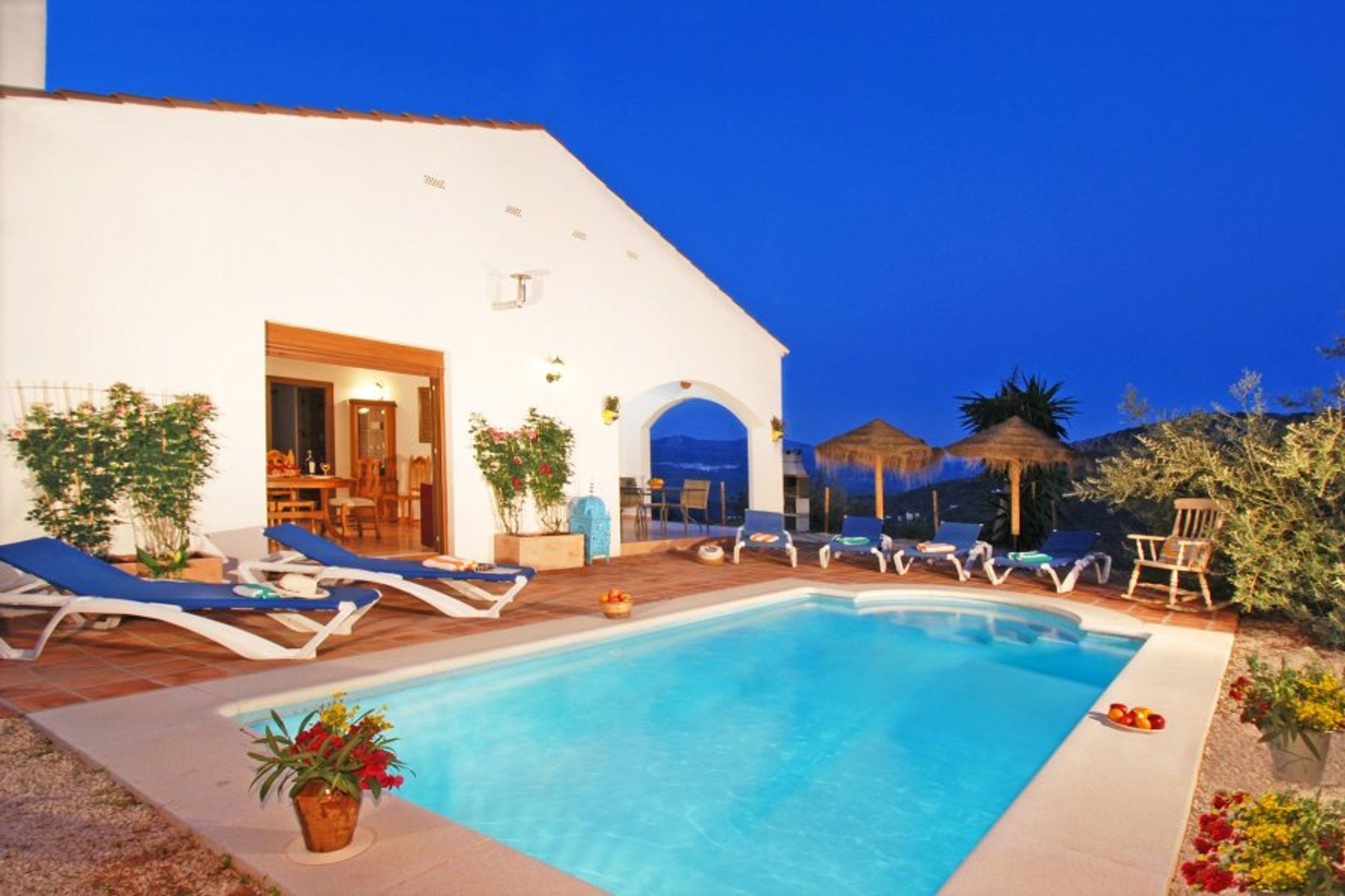 Villa, pool, terraces after the sun has gone down.