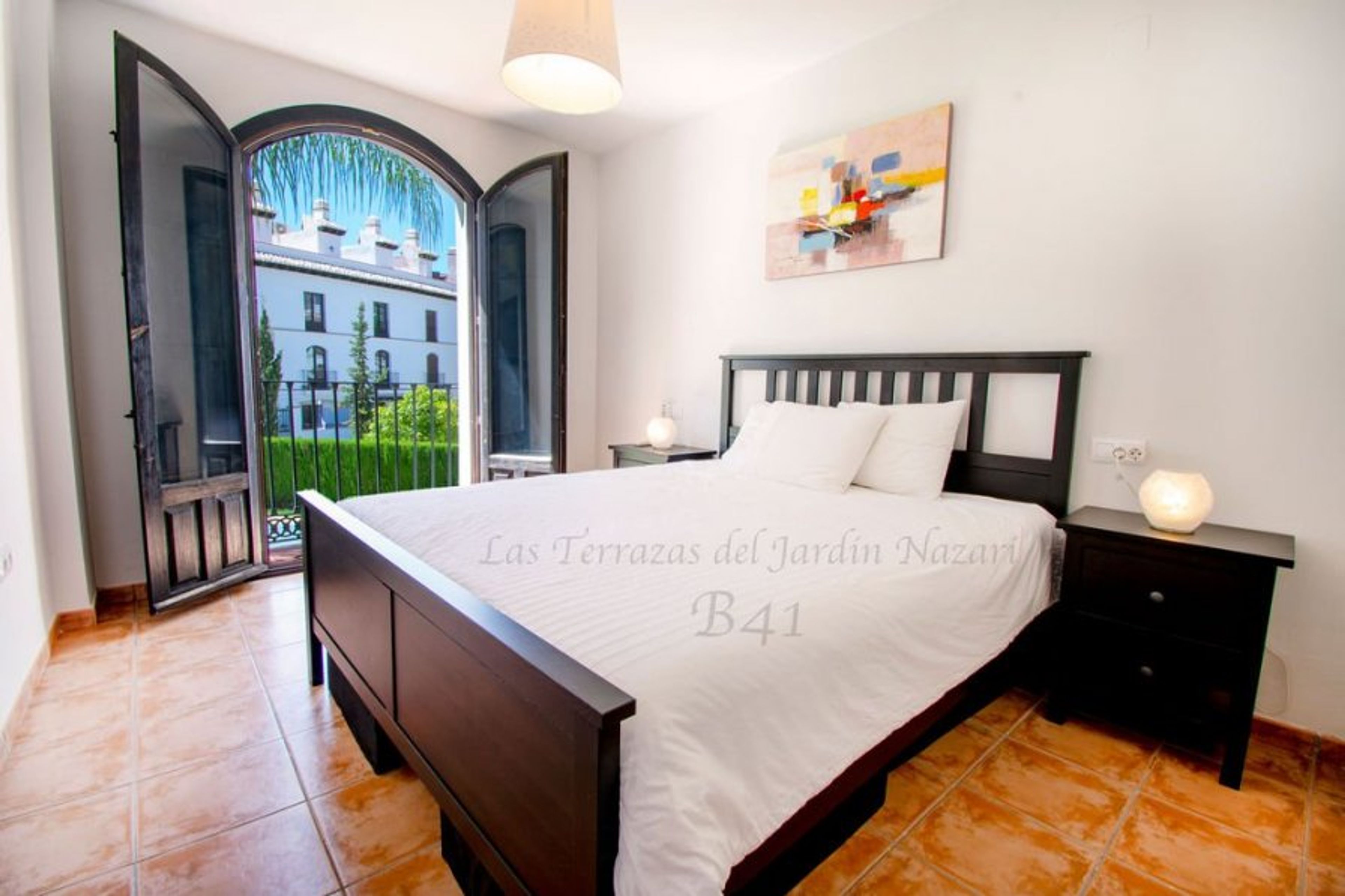 Bedroom one with  its view of the pool from the Juliet balcony 