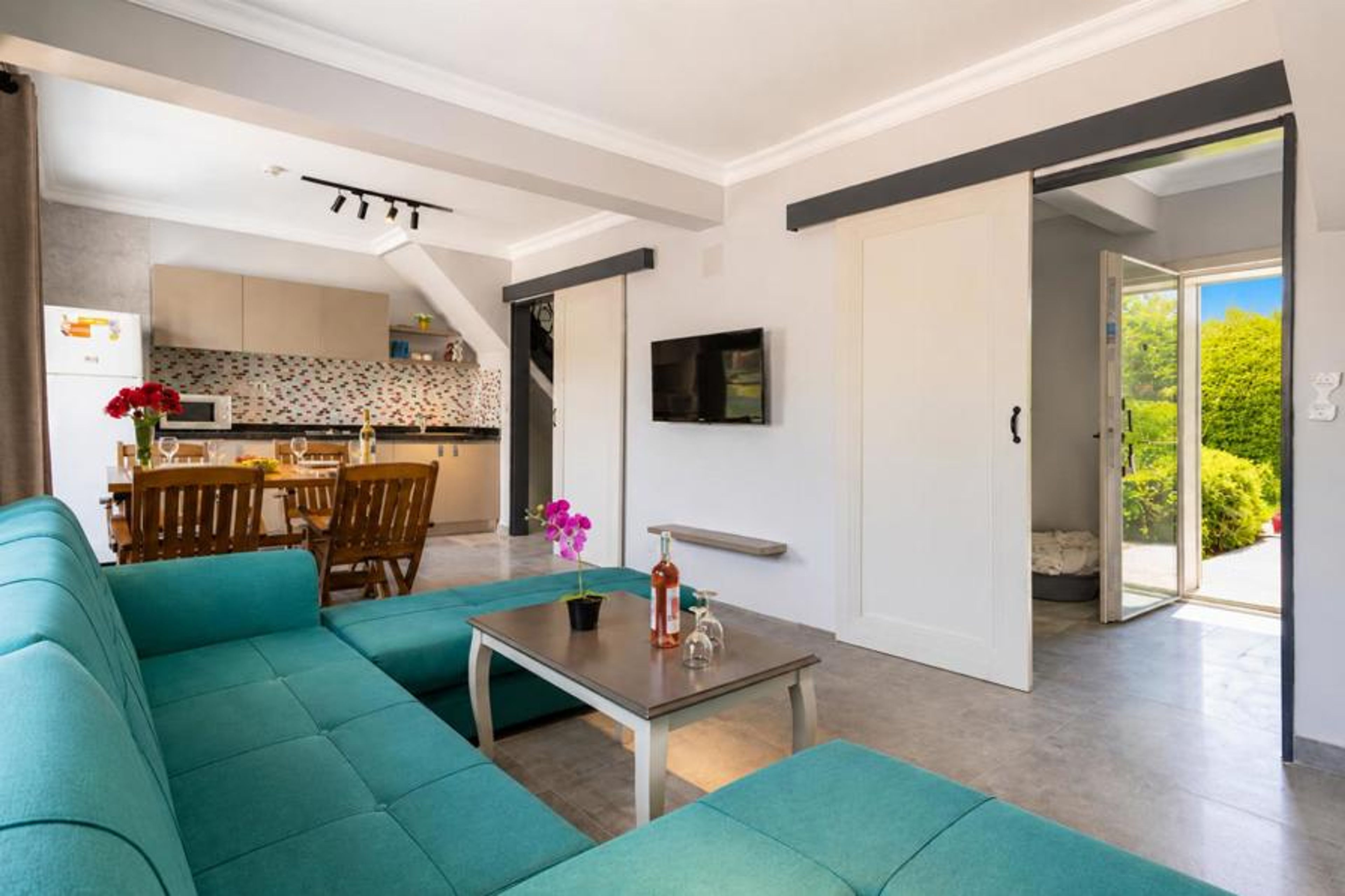 An alternate view of the same open-concept living space, captured from a different angle to highlight the entryways and wall layout.