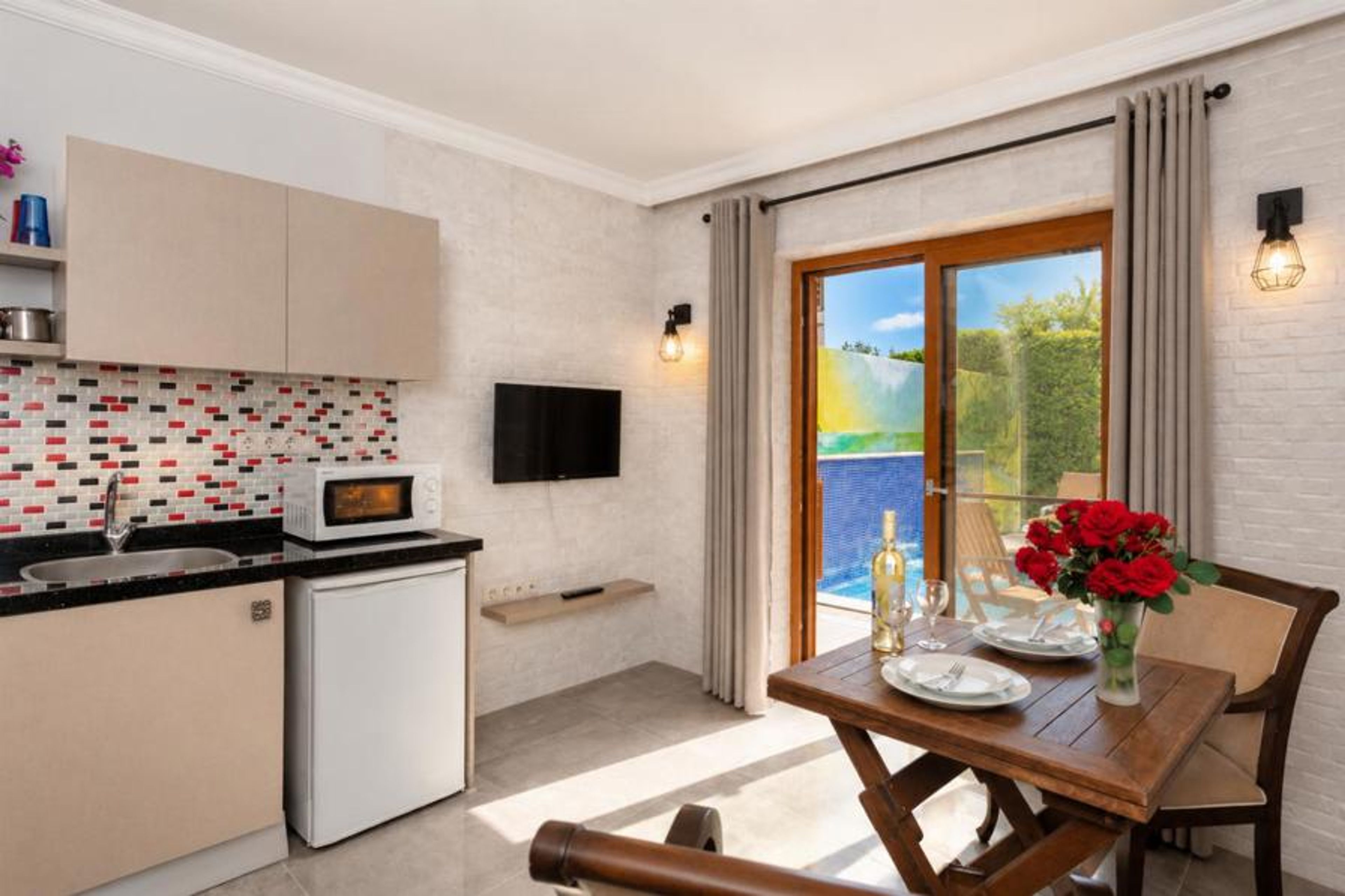 Open-plan living room with dining area, kitchen, A/C, WiFi internet, satellite TV, and pool terrace access