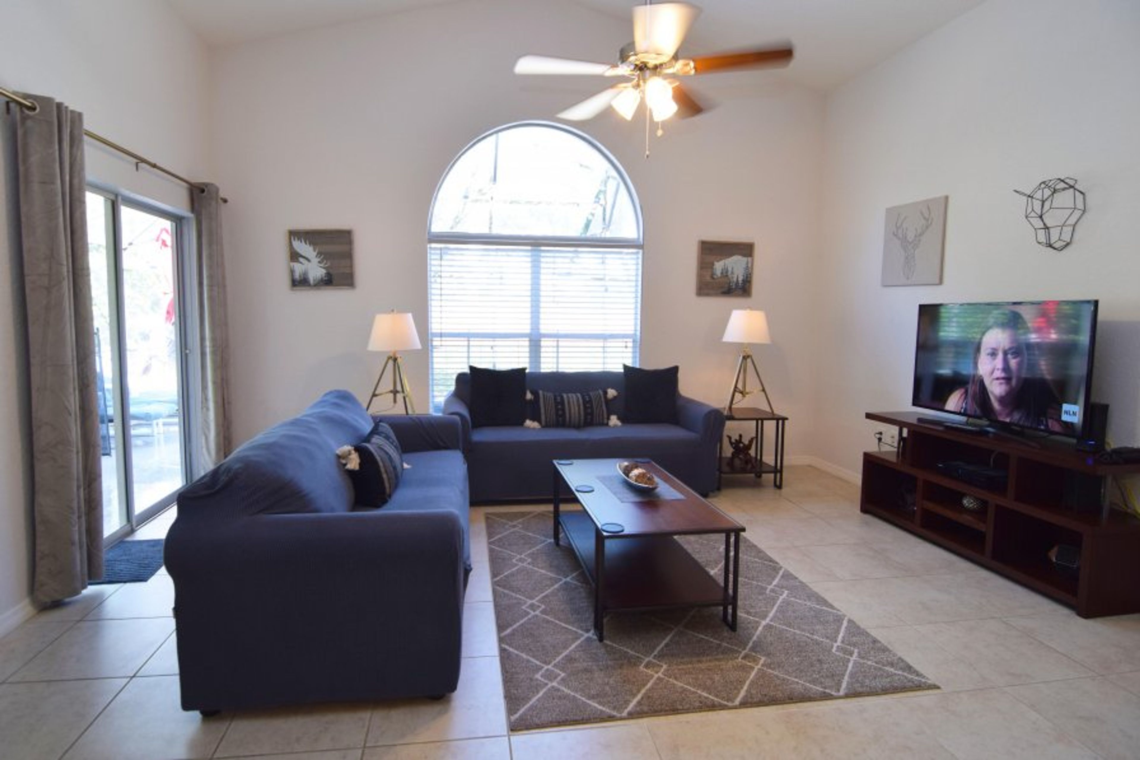 Stylish lounge area with Smart TV, cable, ceiling fan, door to pool