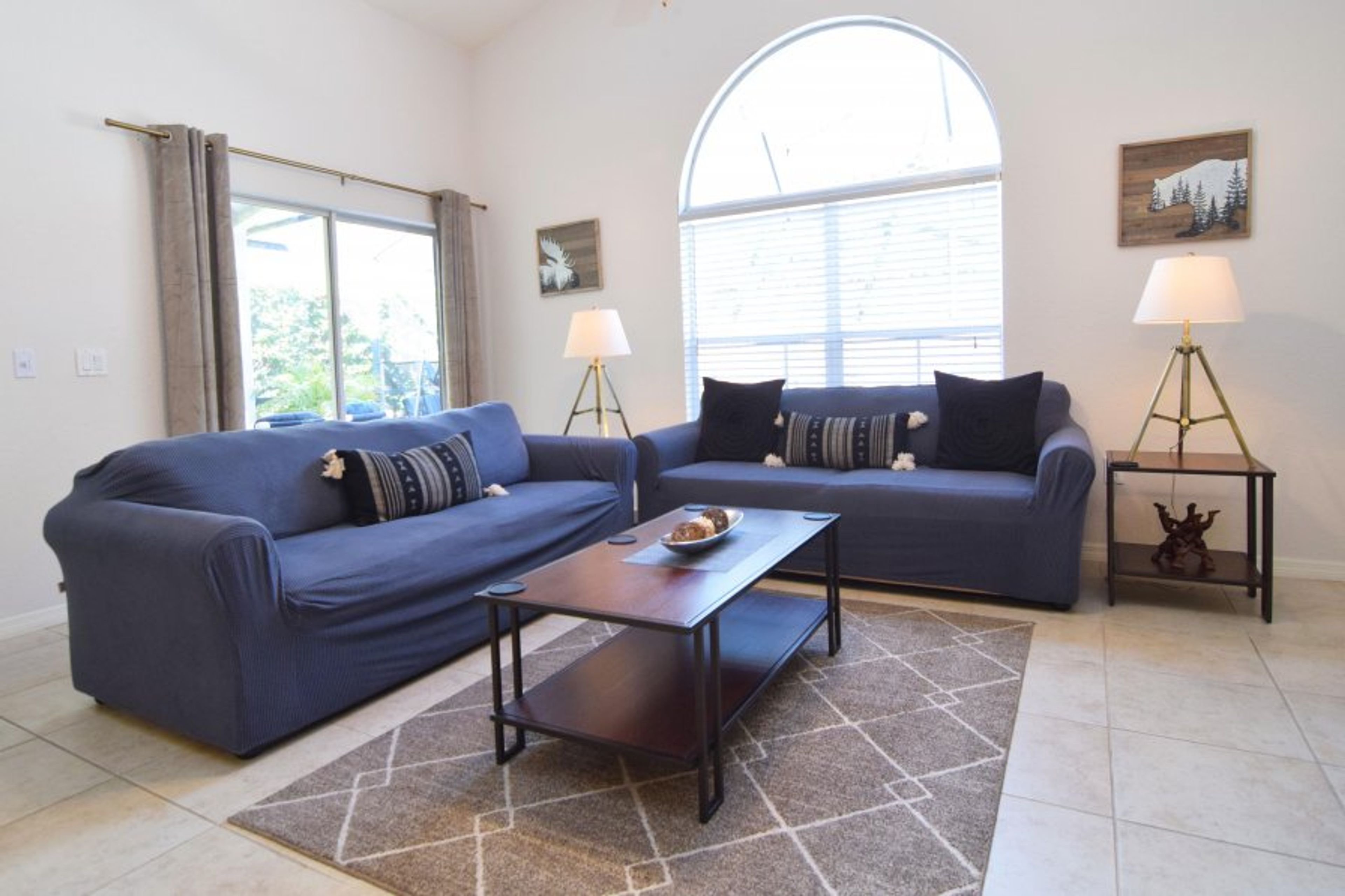 Stylish lounge area with Smart TV, cable, ceiling fan, door to pool