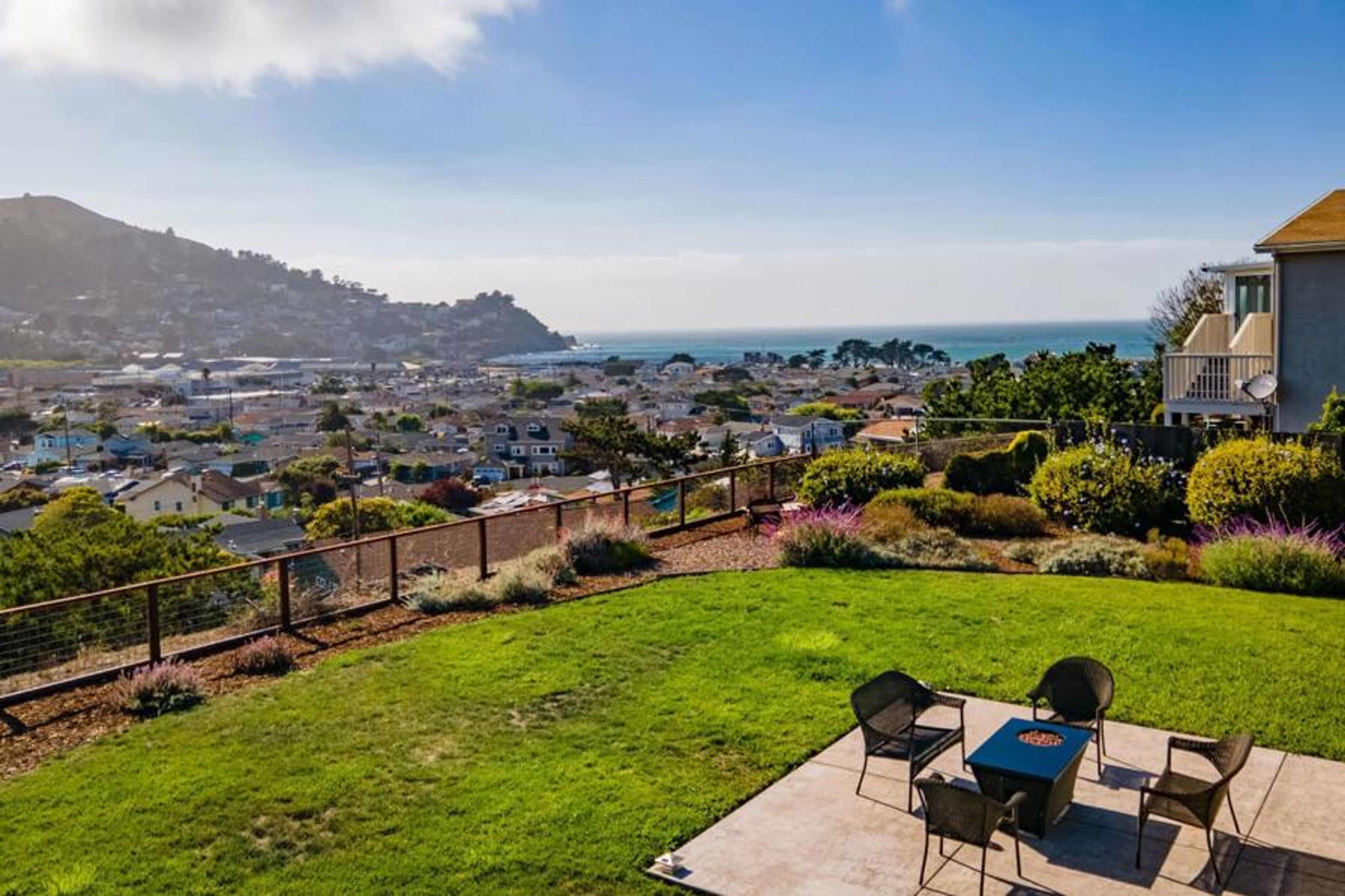 Spacious outdoor seating with table, chairs, and a beautiful ocean view
