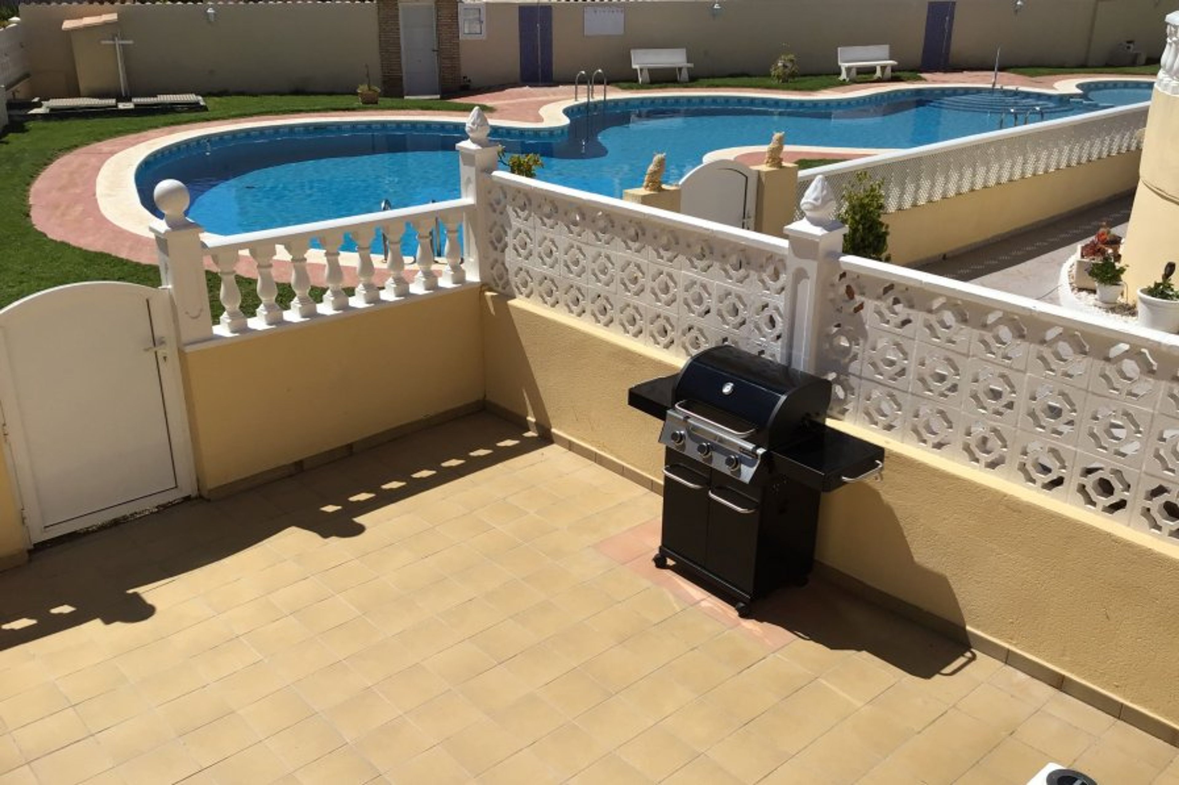 Lower terrace with gas BBQ, gate to pool.