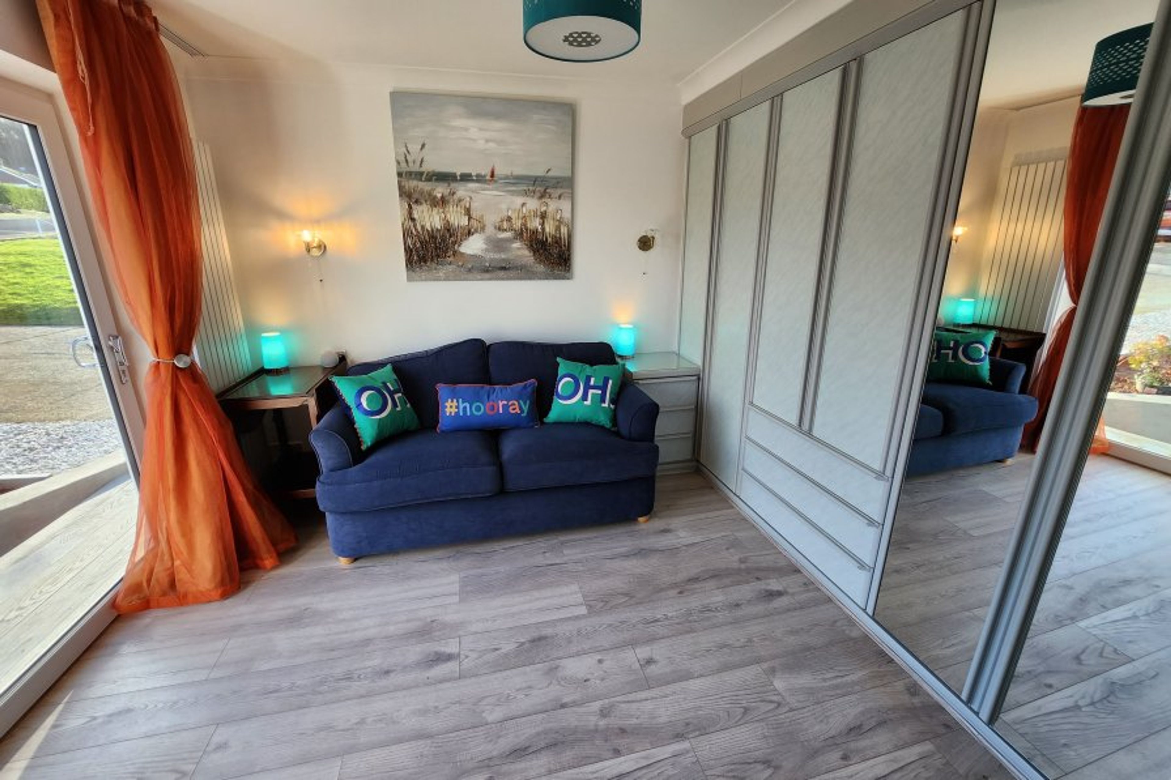 The bright sunny lounge has a large Smart TV & looks onto the garden