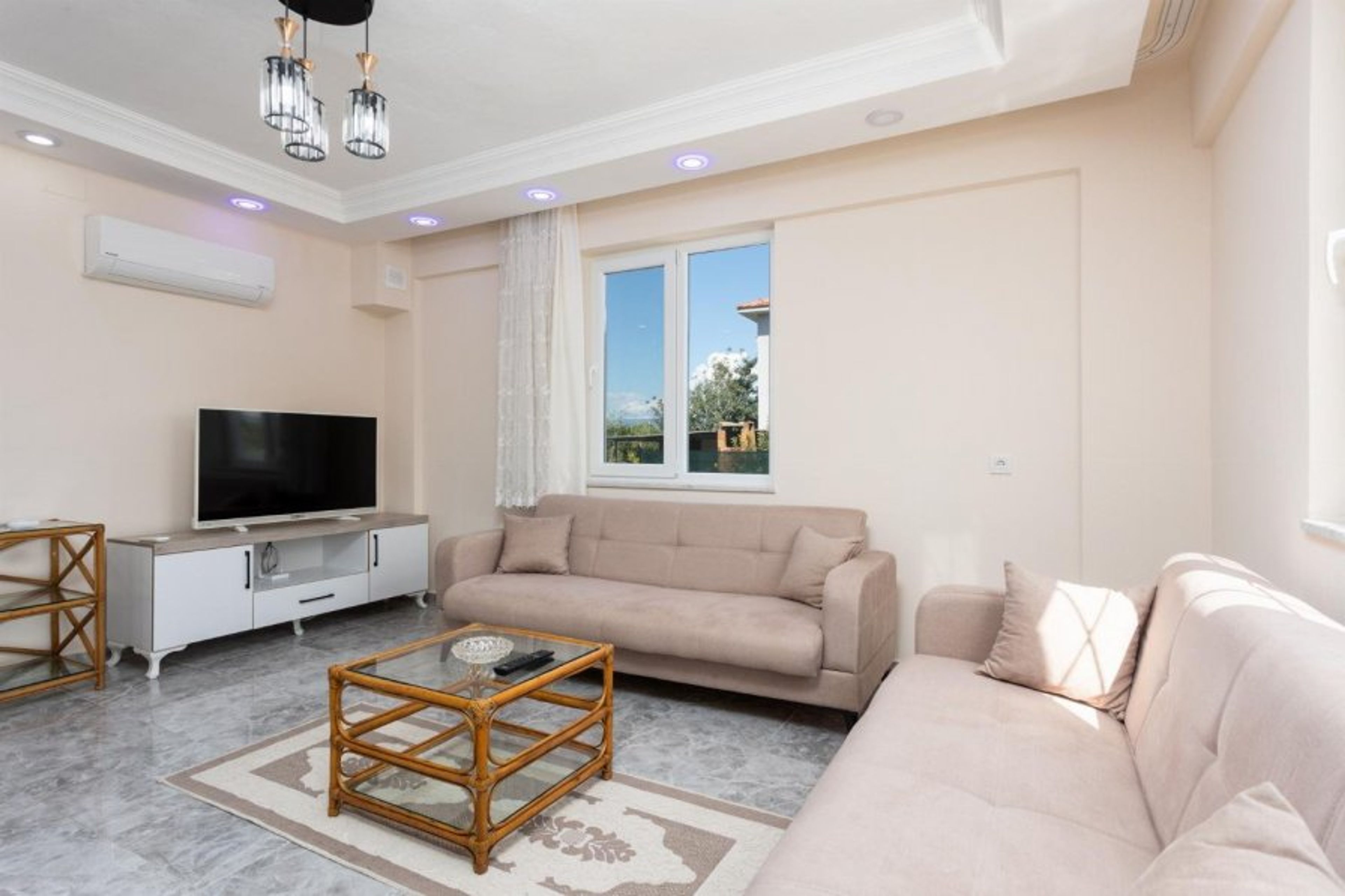 Open-plan living room with sofas, dining area, kitchen, A/C, WiFi internet, and satellite TV