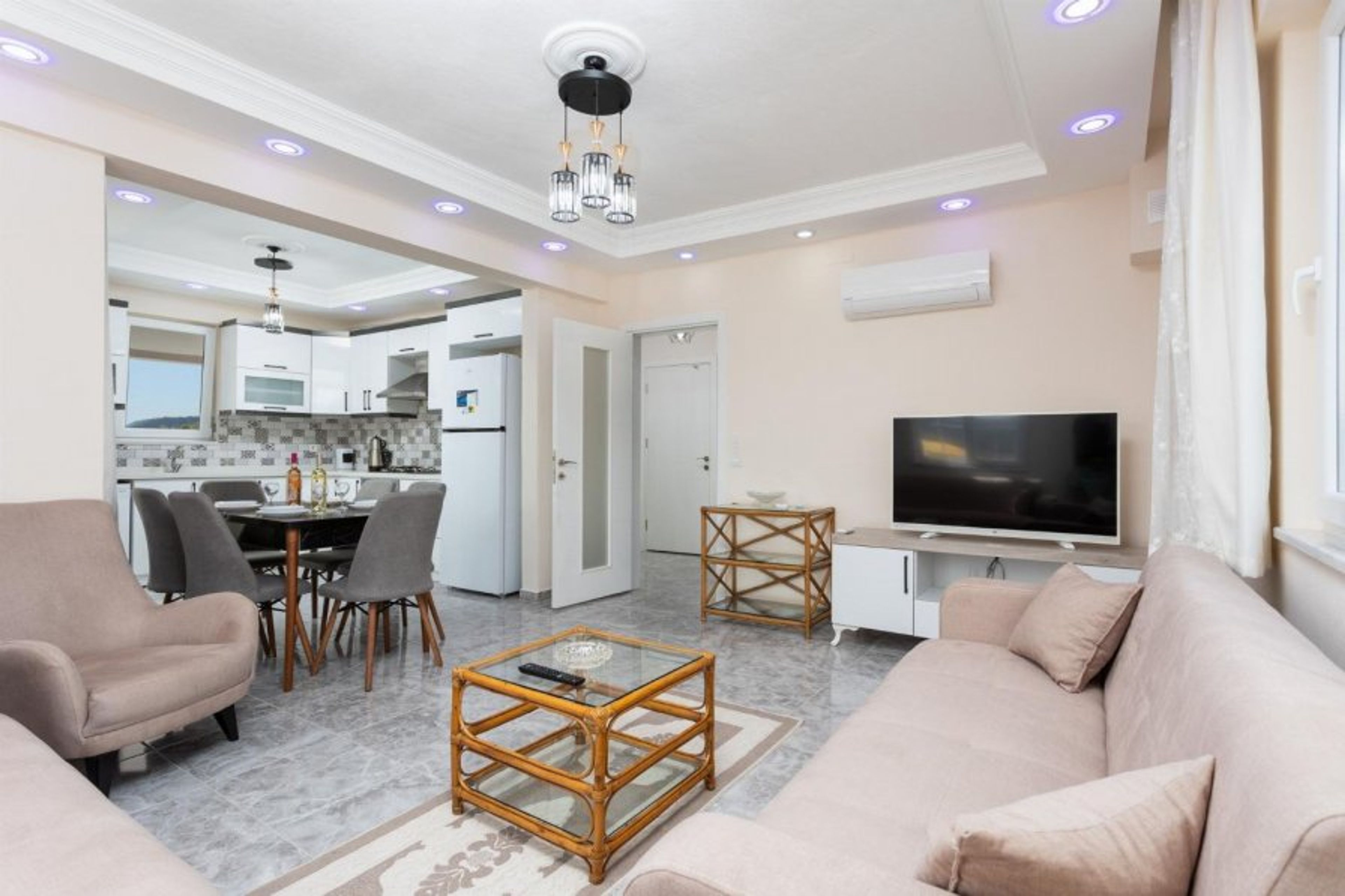 Open-plan living room with sofas, dining area, kitchen, A/C, WiFi internet, and satellite TV