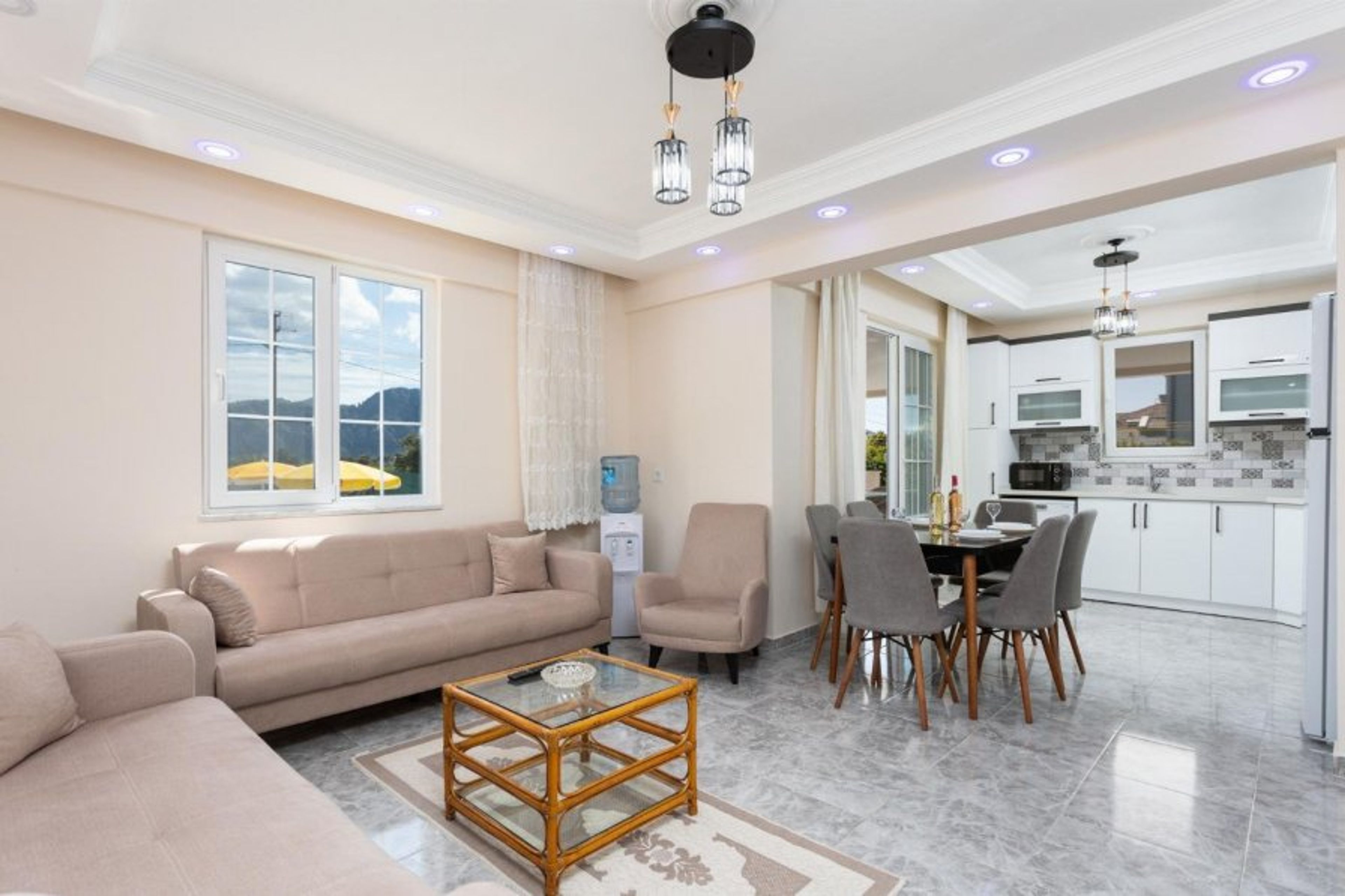 Open-plan living room with sofas, dining area, kitchen, A/C, WiFi internet, and satellite TV