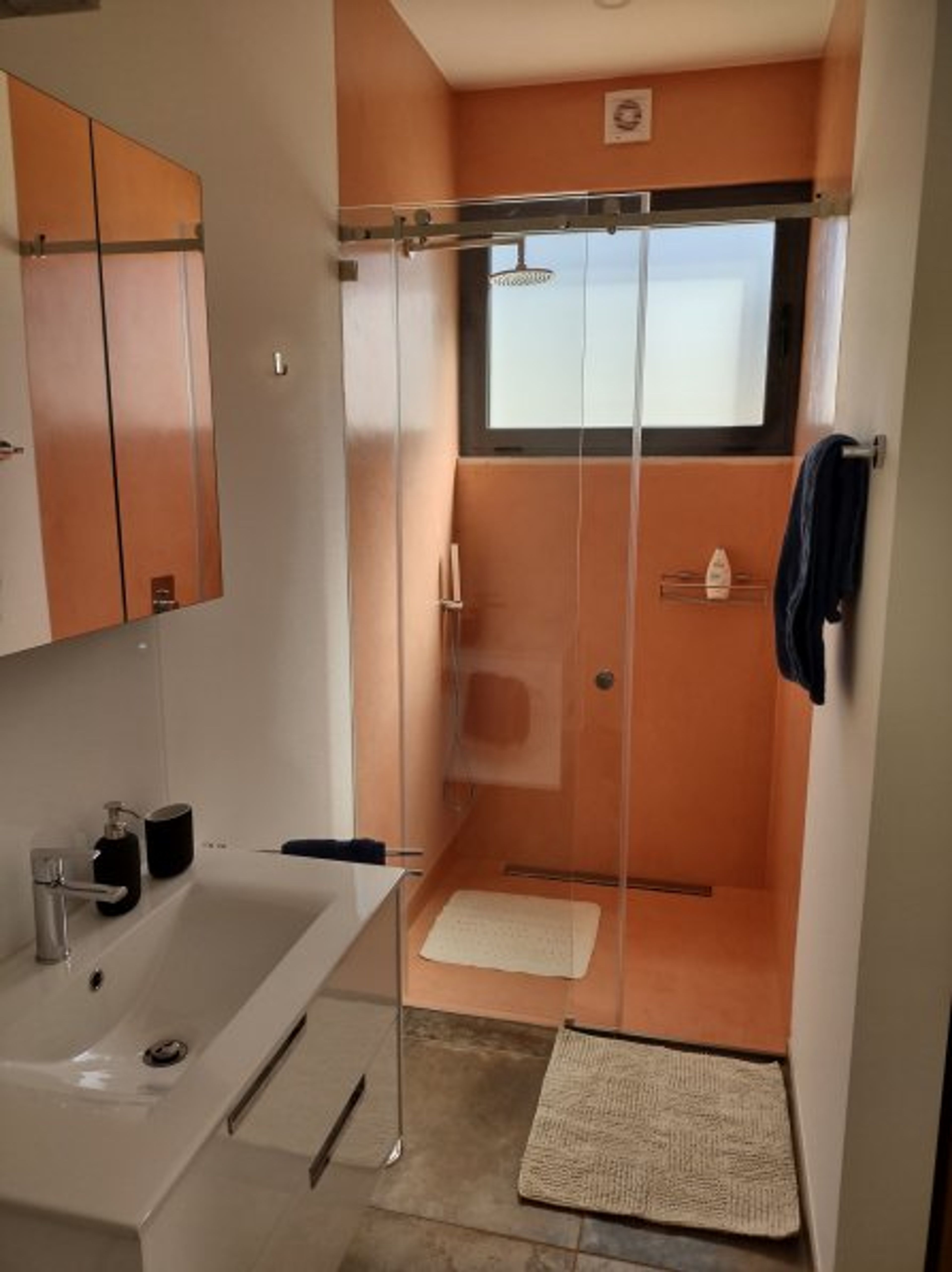 shower sheets, towels, washbasin with mirror cabinet.