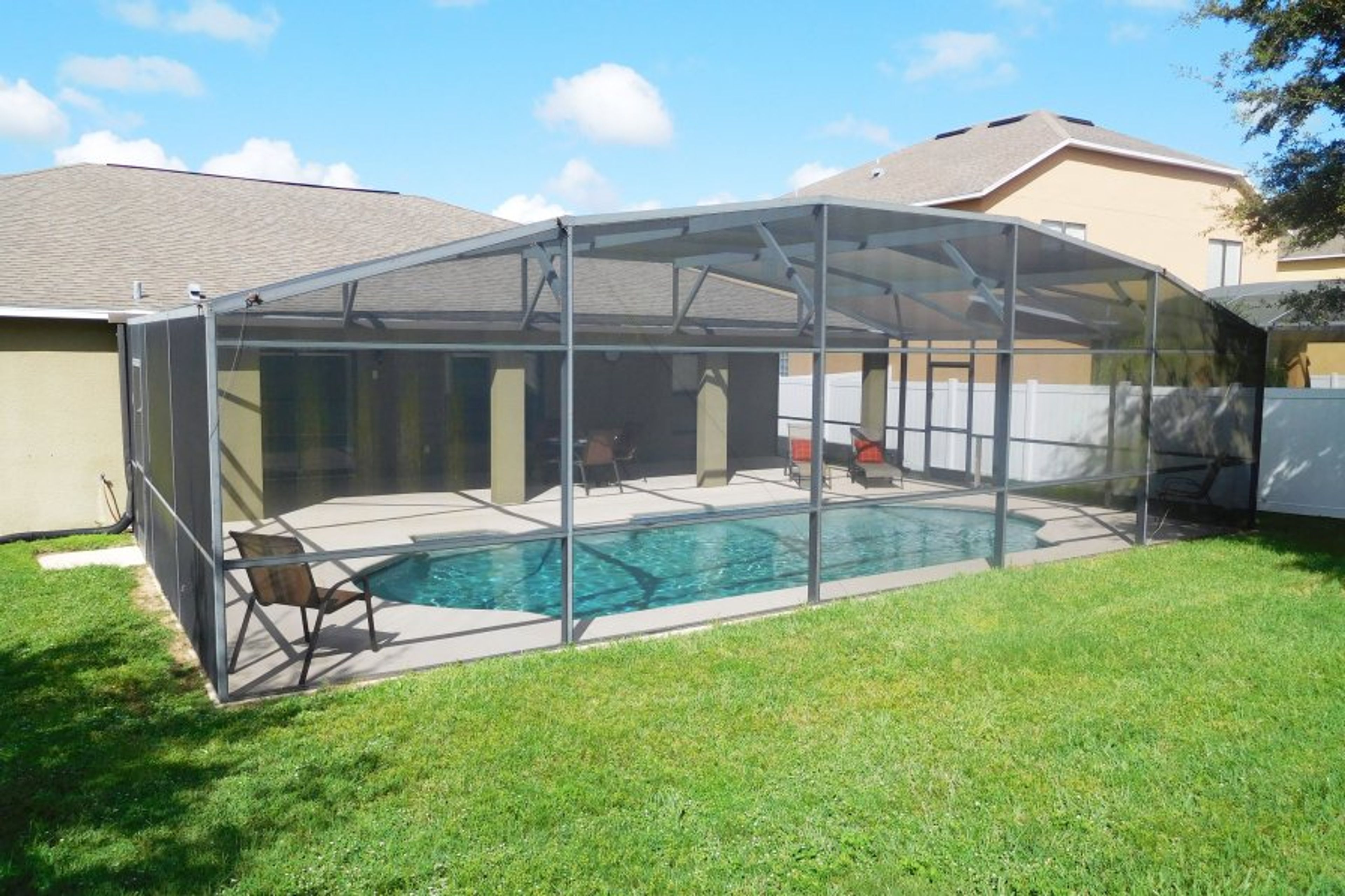 Huge pool with pool deck, loungers, comfortable seating, pool fence