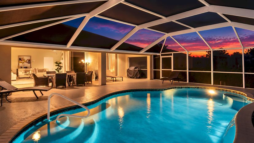 Villa in USA, Cape Coral: The illuminated pool and colorful sunset create a beautiful evening atmo..