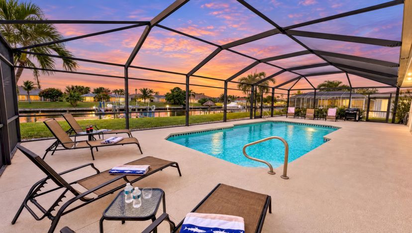 Villa in USA, Cape Coral: A beautiful sunset over the screened-in pool area, with comfortable loun..