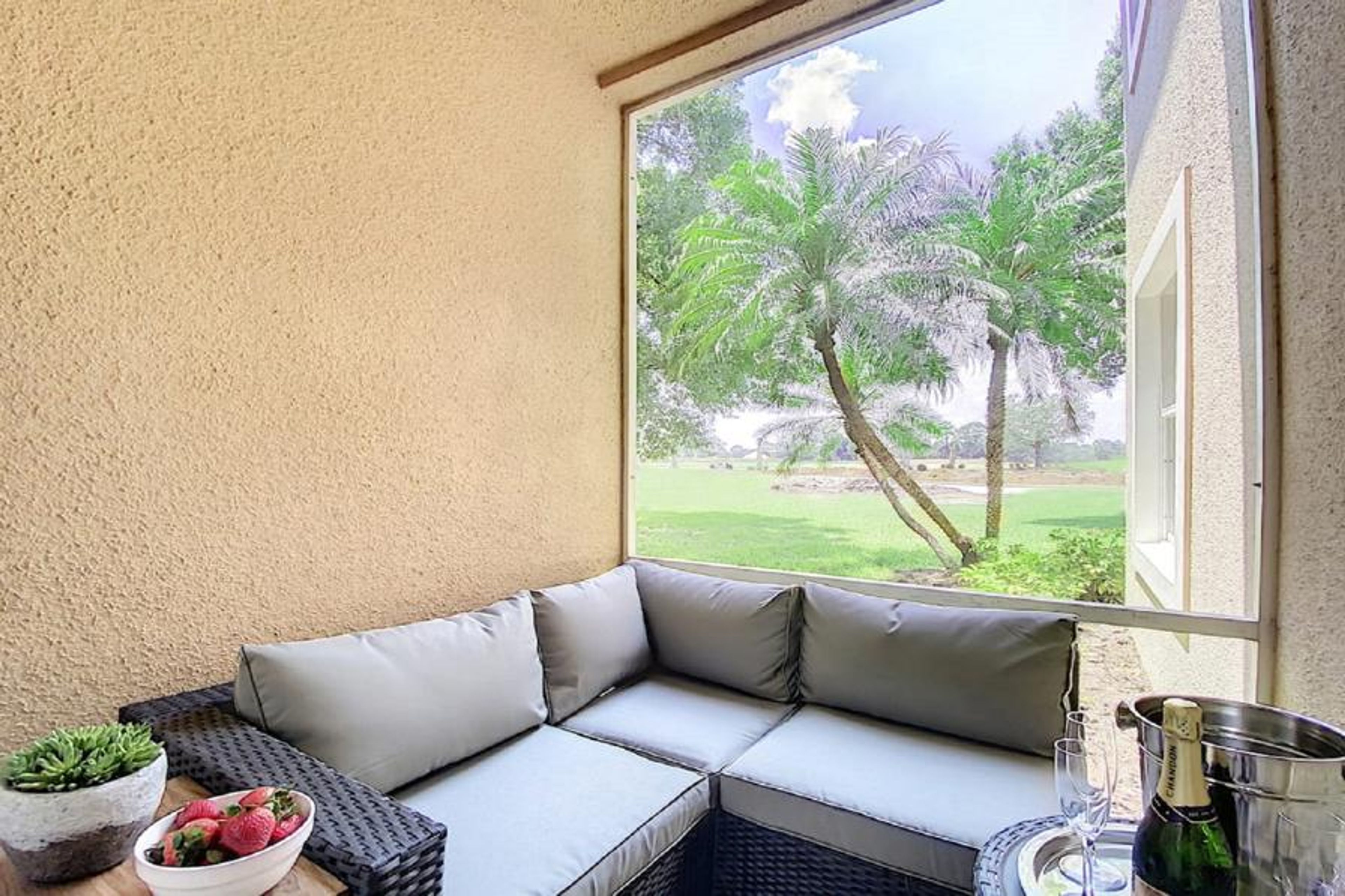Outdoor Livingroom Patio with TV on wall and overlooking PGA Clubhouse and Learning Center
