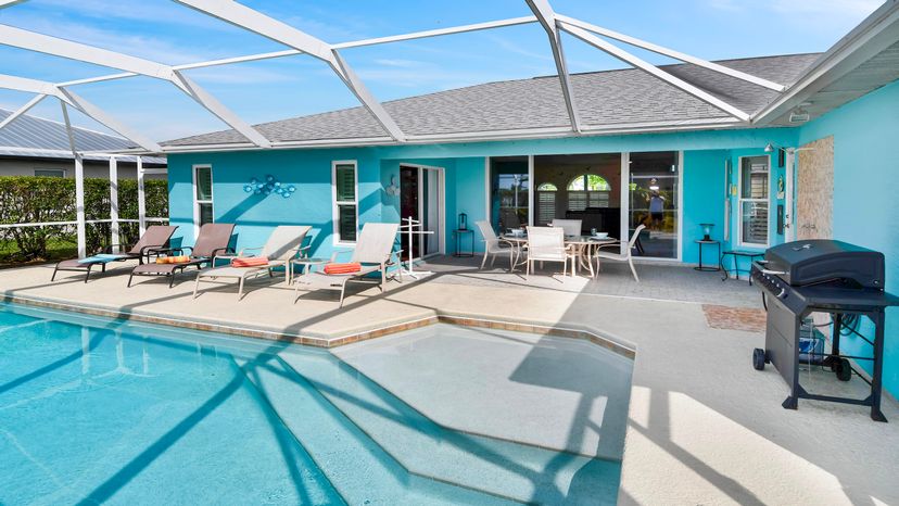 Villa in USA, Cape Coral: The sunny pool deck features four loungers, a screened swimming pool, an..