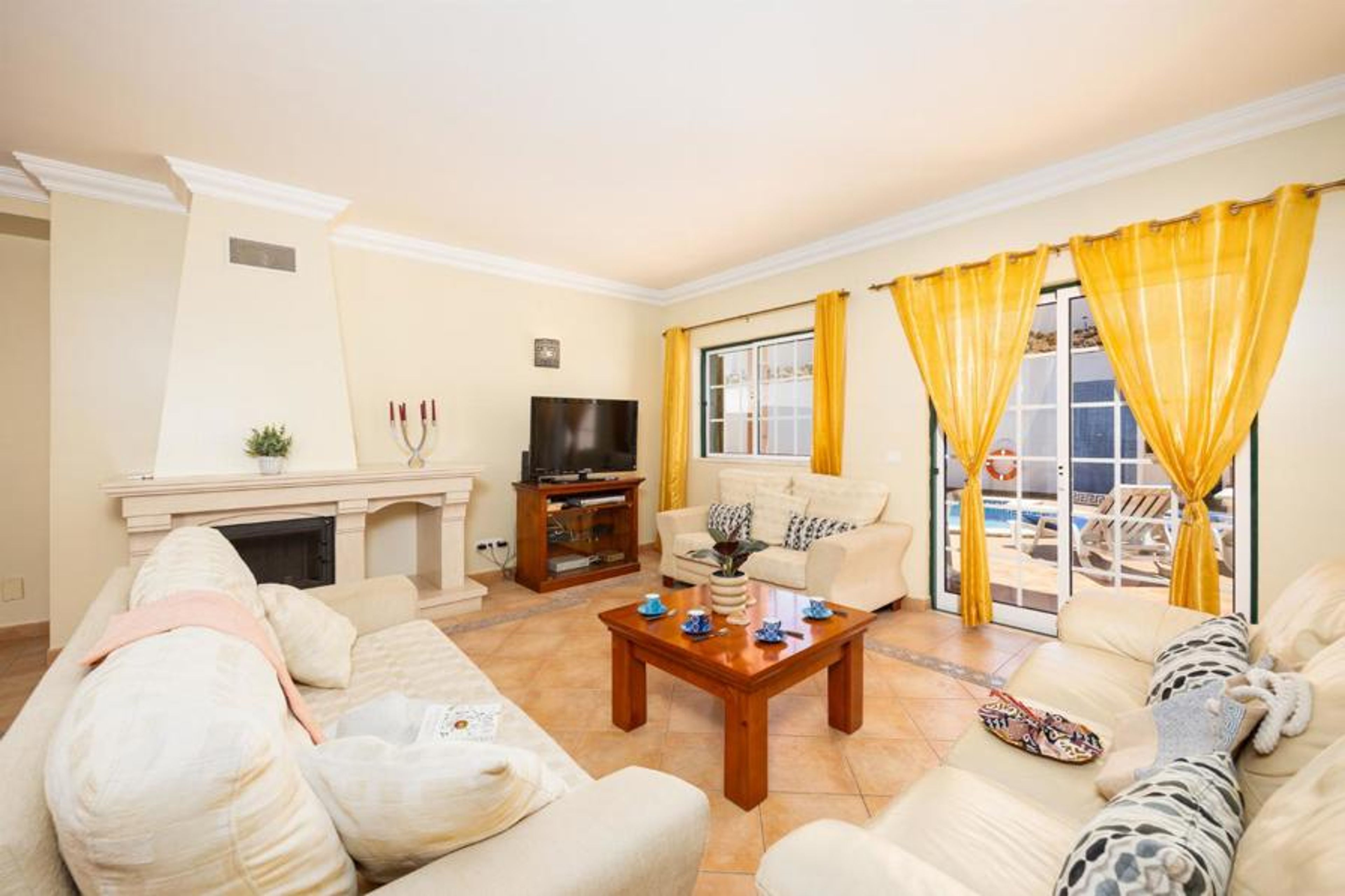 Open-plan living room with sofas, dining area, ornamental fireplace, A/C, WiFi internet, and satellite TV