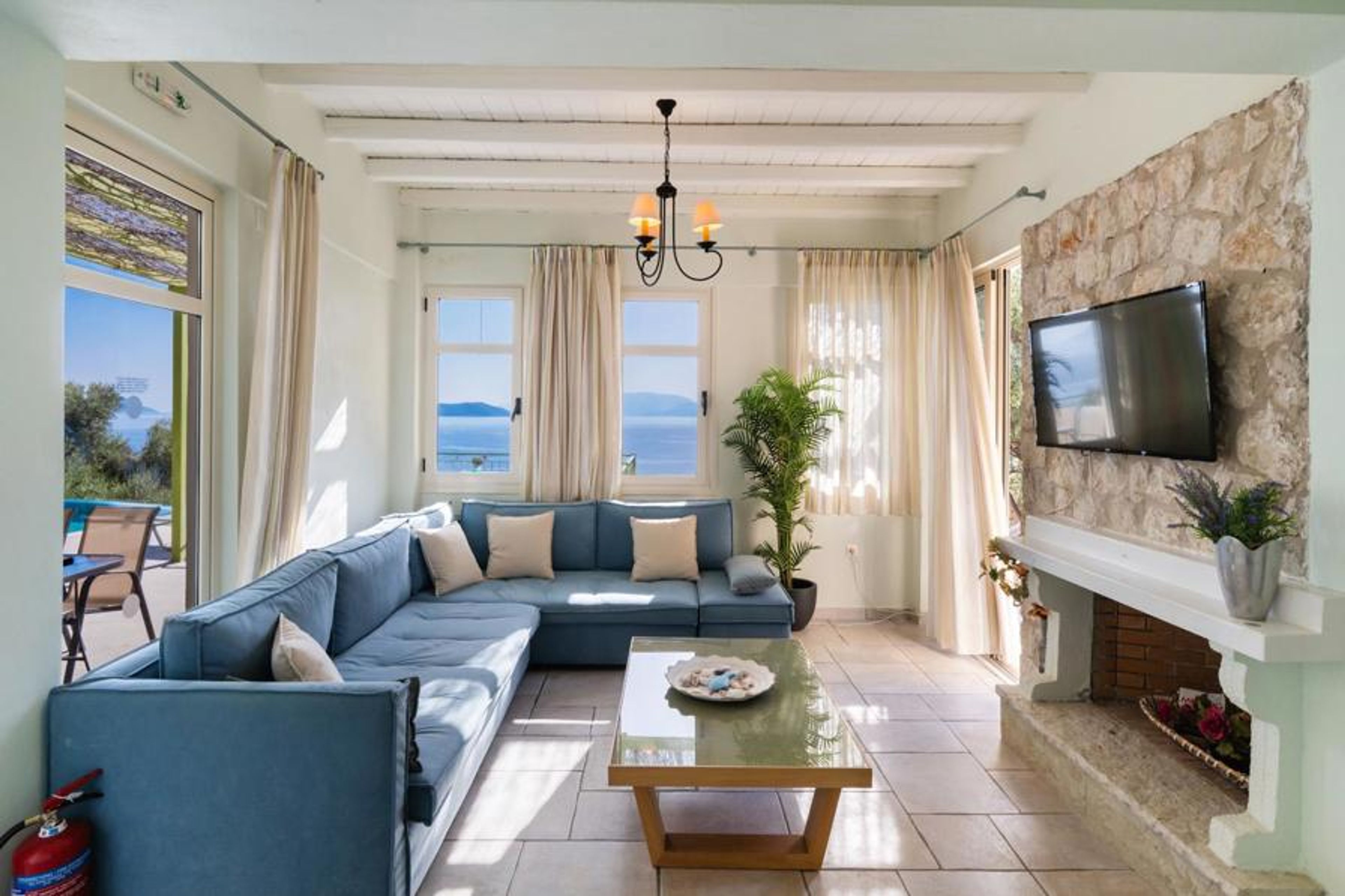 Open-plan living room with sofa, dining area, kitchen, A/C, WiFi internet, and satellite TV