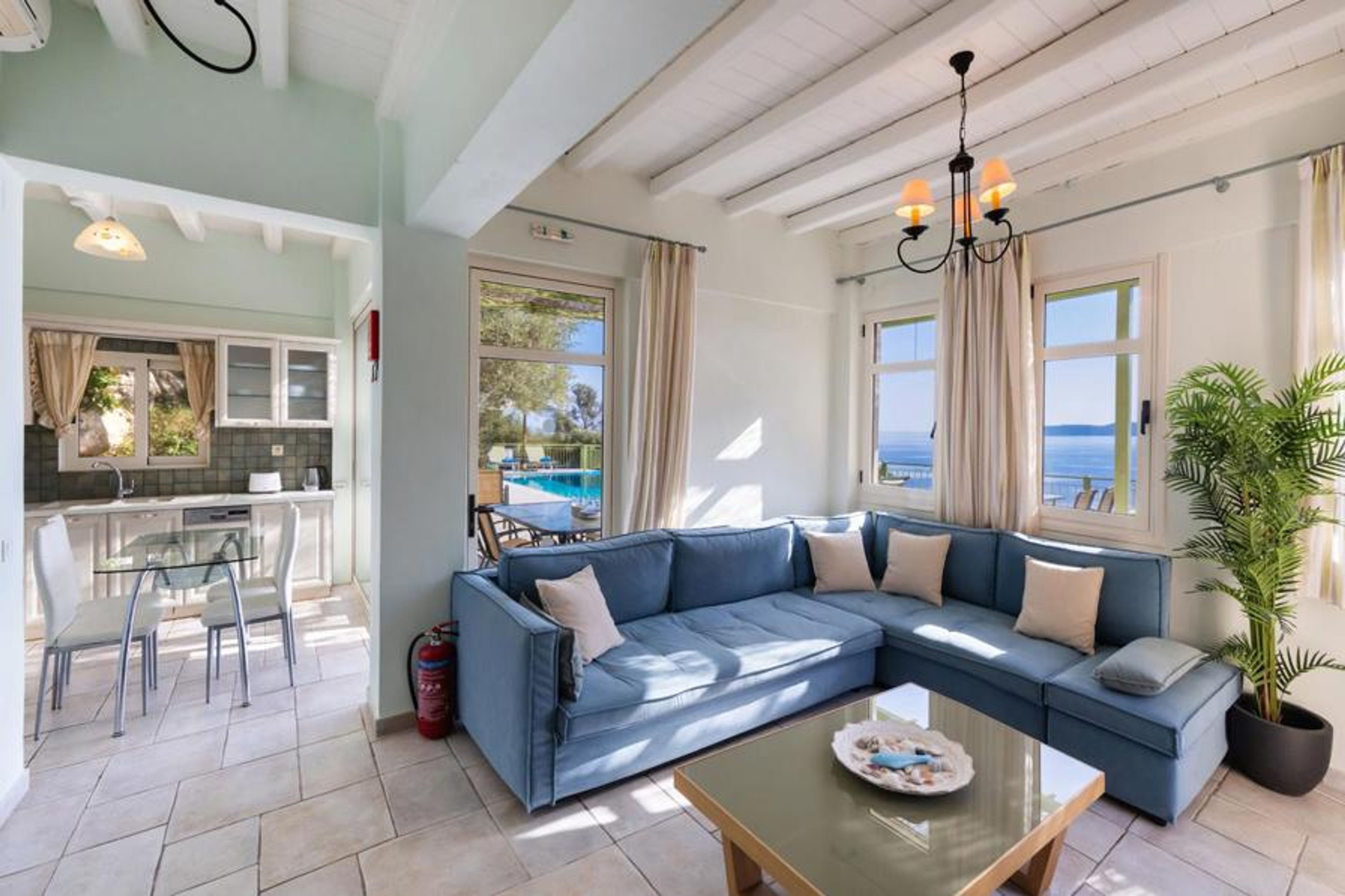 Open-plan living room with sofa, dining area, kitchen, A/C, WiFi internet, and satellite TV