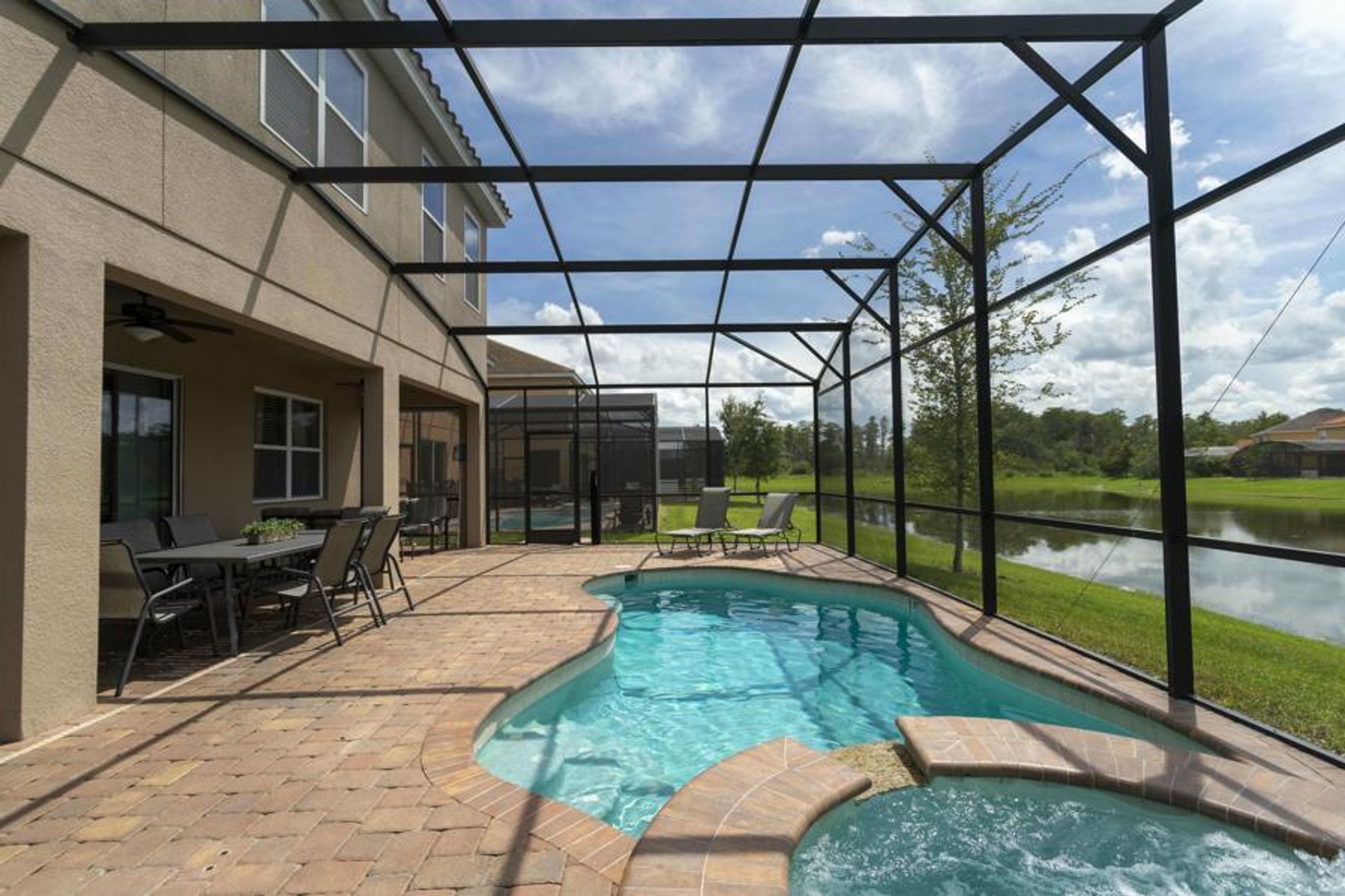 Step into your own private oasis with a sparkling pool framed by a spacious screened patio, where the gentle curve of the water invites relaxation. Enjoy al fresco dining with a view of the serene pond, perfect for unwinding.
