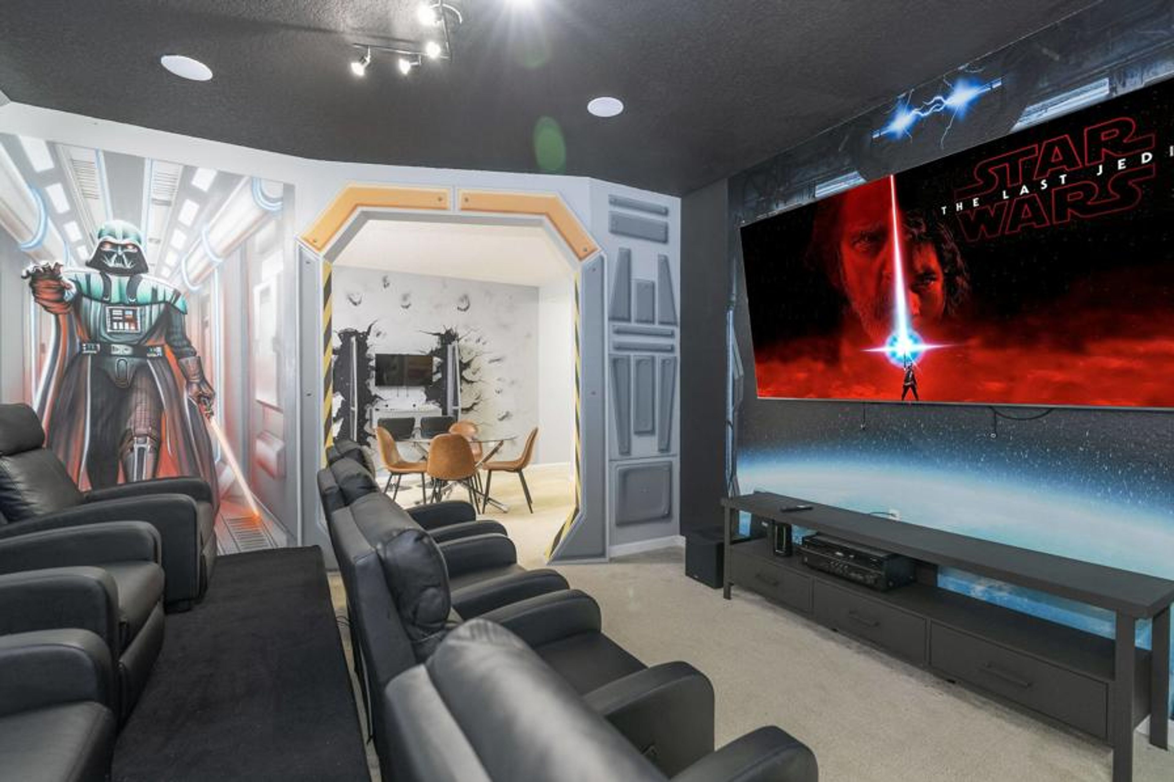 Experience cinematic magic in our uniquely designed home theater featuring plush black leather seating and themed wall art. Enjoy a large screen for your favorite films, making every movie night truly unforgettable.