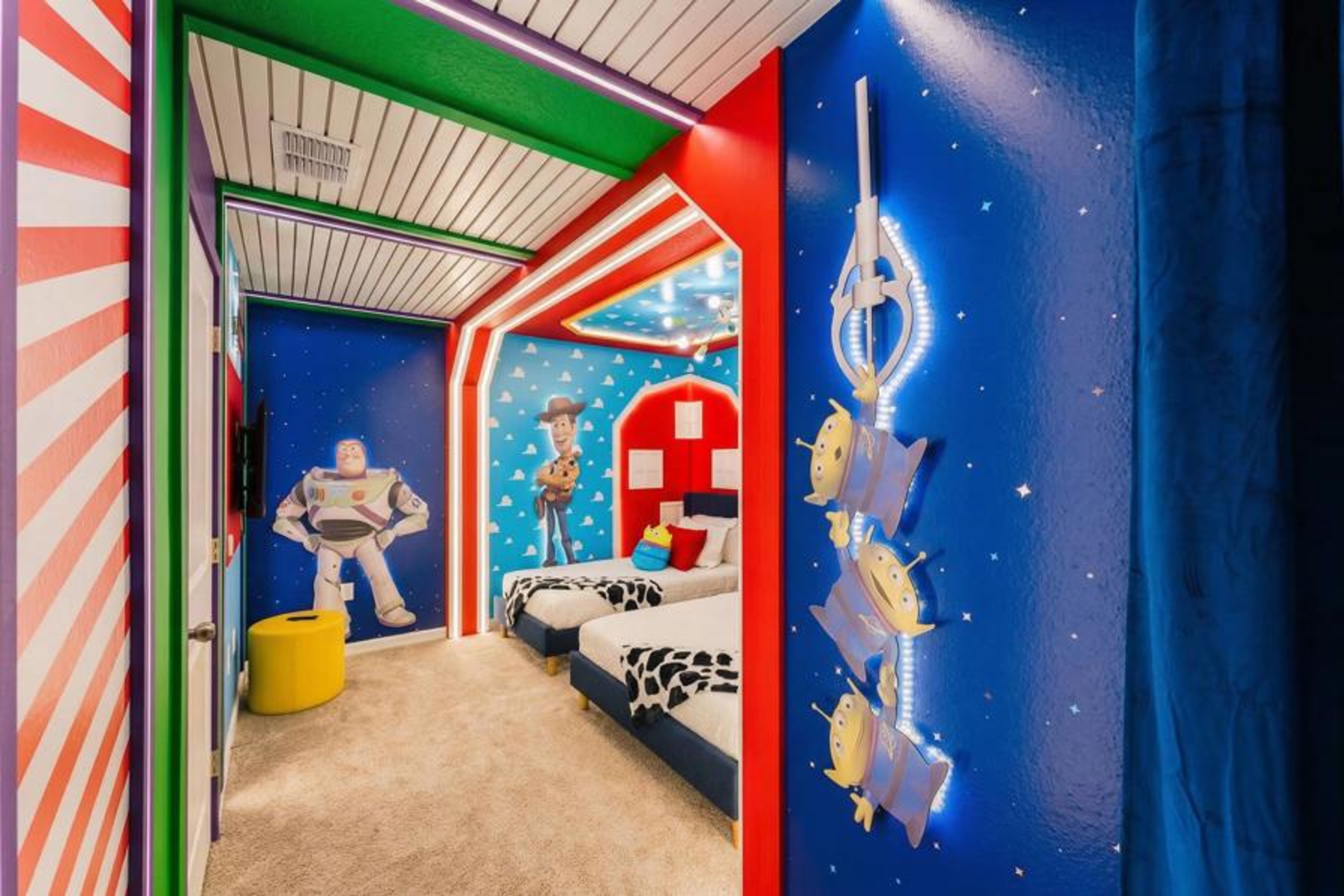 Step into a playful haven adorned with vibrant stripes and whimsical character murals, where two cozy beds await beneath a starry sky. The cheerful decor and inviting textures create a delightful atmosphere for guests of all ages.