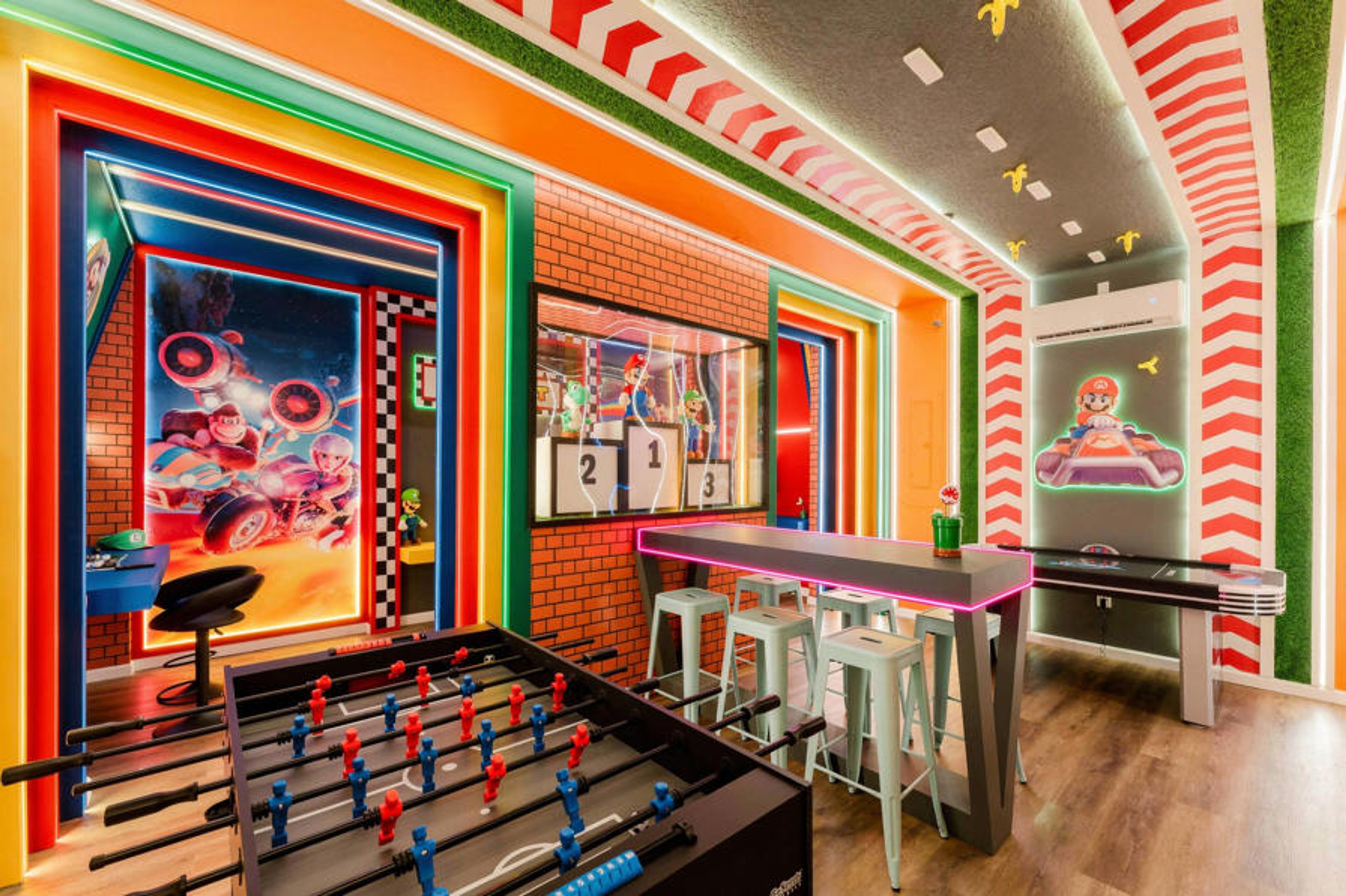 Discover a lively game room adorned with colorful decor, featuring a foosball table and stylish bar-height seating. Enjoy the vibrant hues and dynamic artwork, setting the perfect atmosphere for memorable, fun-filled evenings.