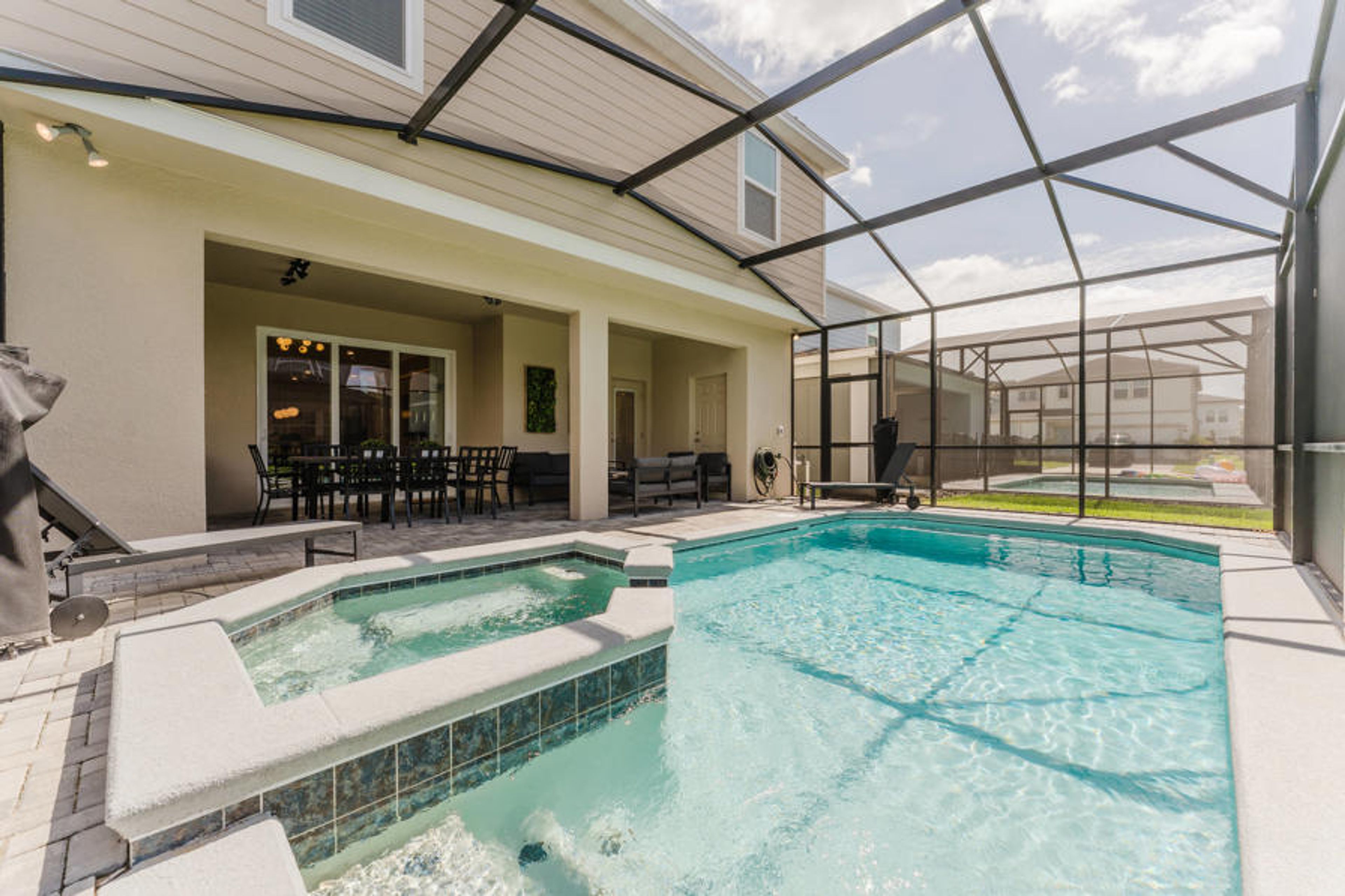 Step outside to enjoy a sunlit pool area featuring a refreshing spa and a spacious deck for lounging. The vibrant tile and mosaic accents create an inviting atmosphere for relaxation and gatherings in comfort.
