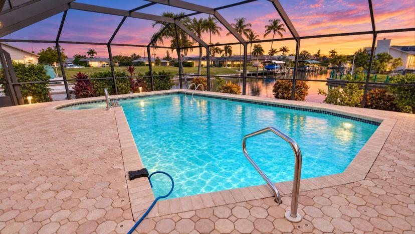 Villa in USA, Cape Coral: Private screened-in pool with a beautiful sunset backdrop, palm trees, a..