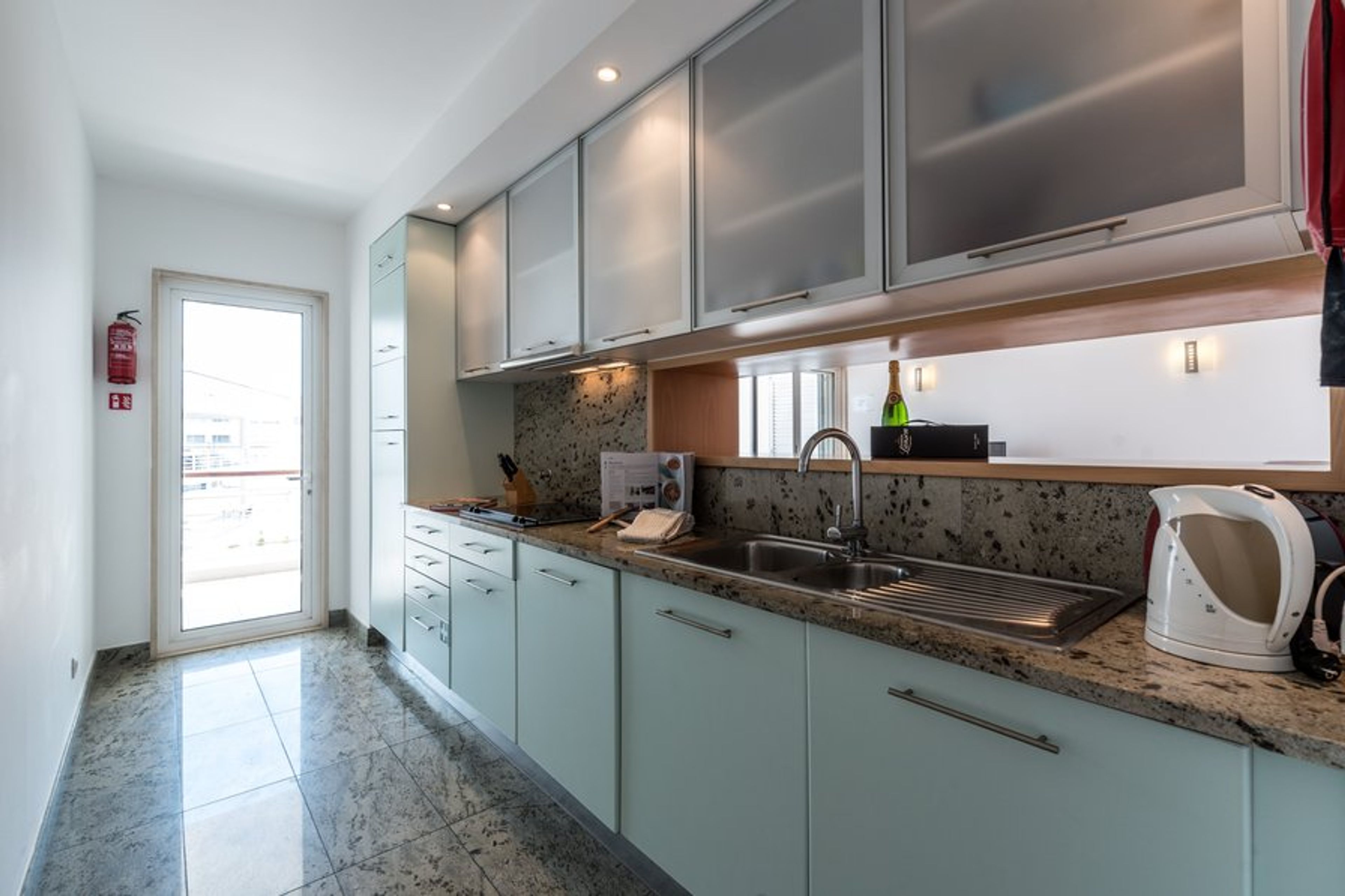 Galley-style kitchen with 'fridge, freezer, hob,microwave & washer.
