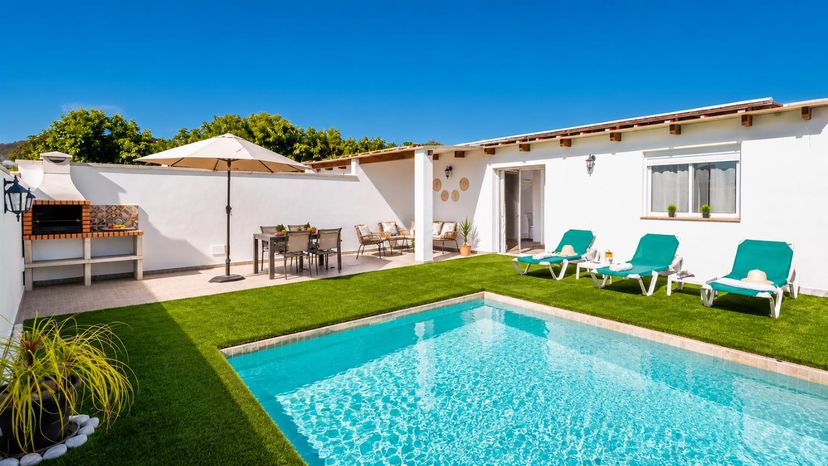 Villa in Spain, Nerja: A sunny villa pool terrace with loungers, outdoor dining, and a built-in ba..